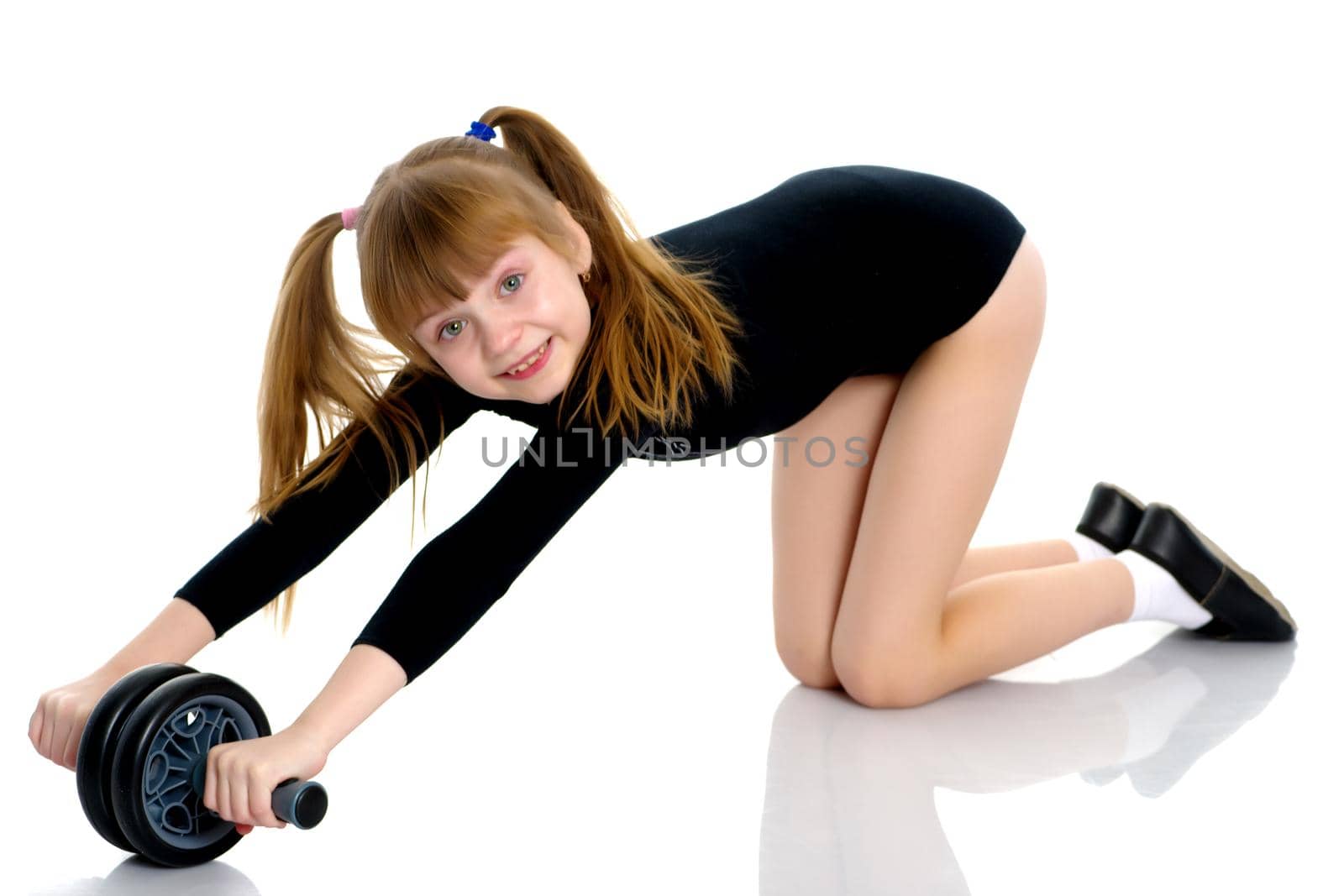 A nice little girl is performing gymnastic exercises. Concept of a healthy lifestyle, sport and fitness. Isolated on white background.