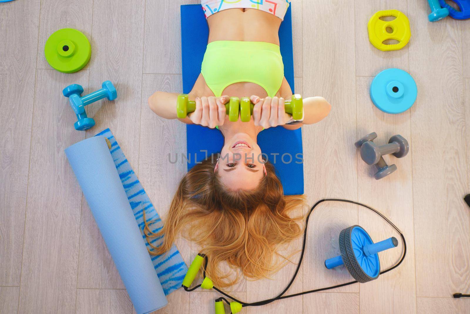 Girl blonde with fitness accessories, top view.
