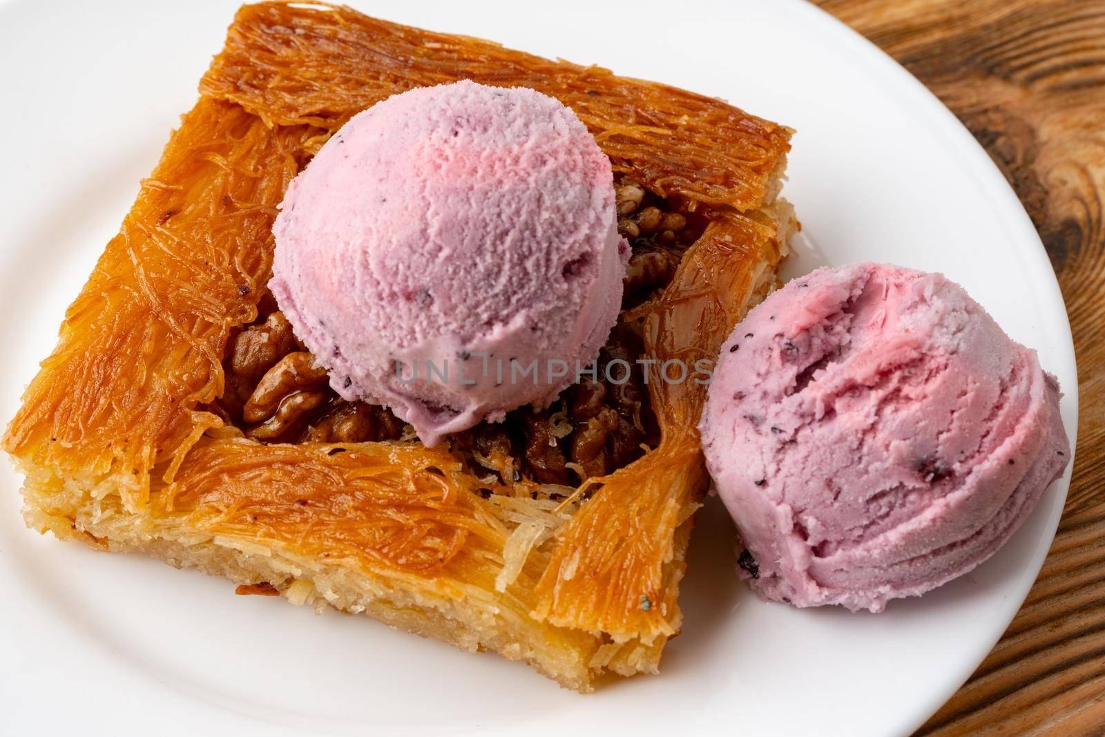 Turkish dessert kunefe served with ice cream on wooden background by Fabrikasimf