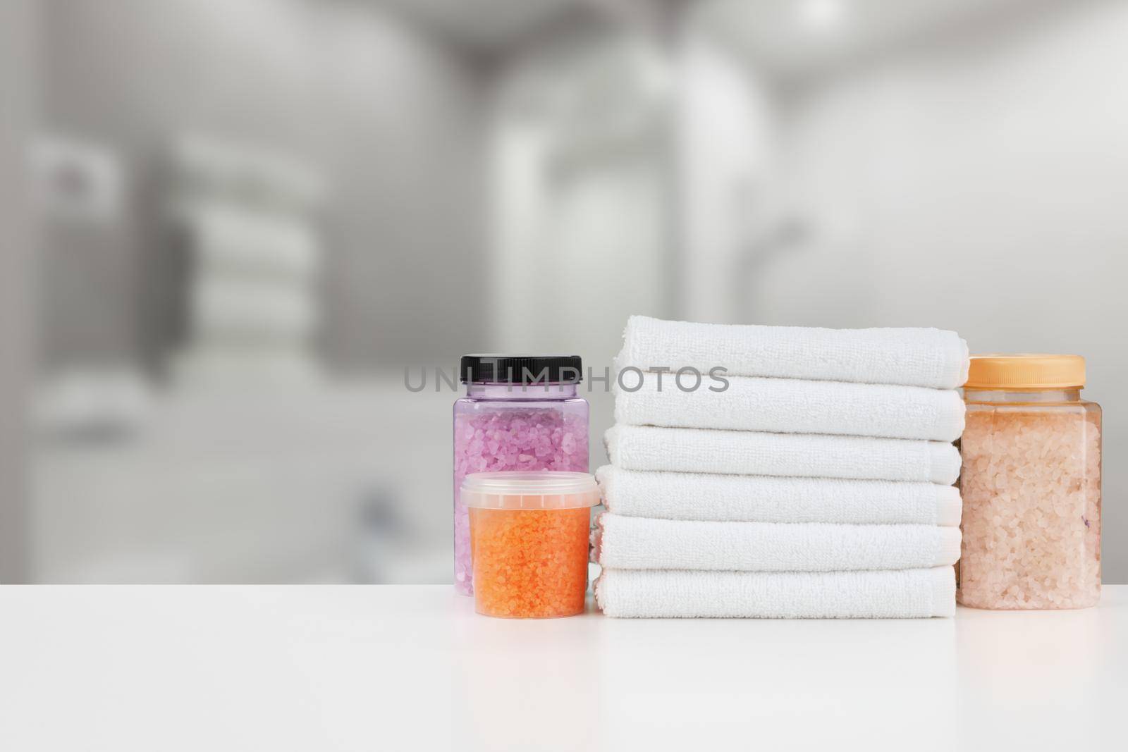 Various spa beauty threatment products and towels against blurred background by Fabrikasimf