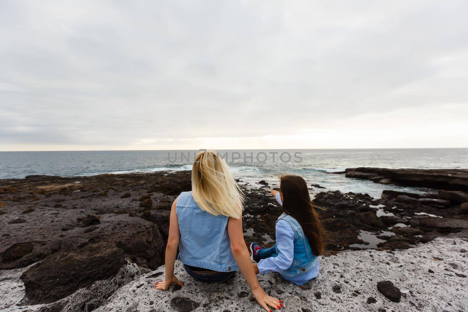 mother and daughter are walking near the ocean on the island of tenerife by Andelov13