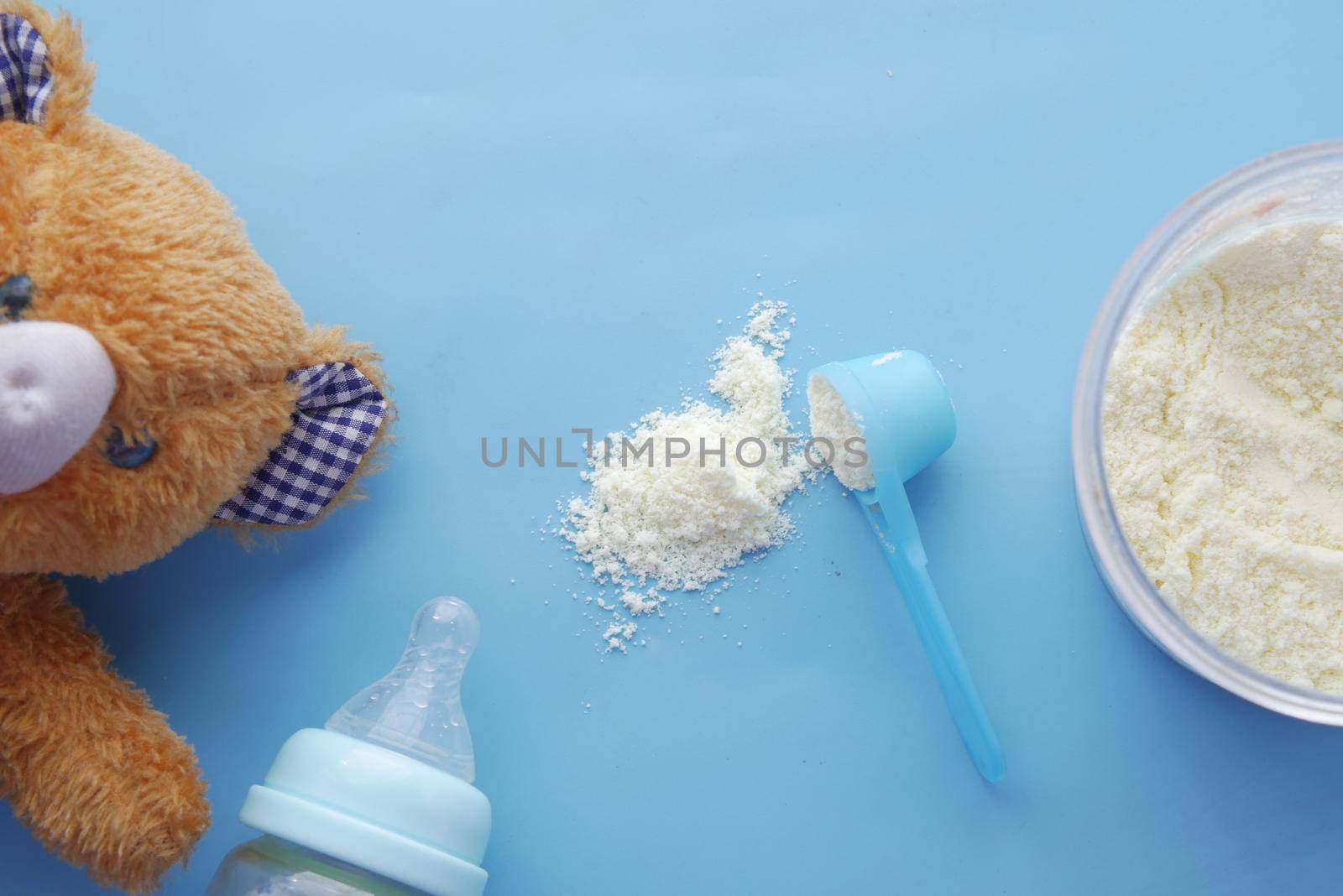 Close up of baby milk powder and spoon on tile background