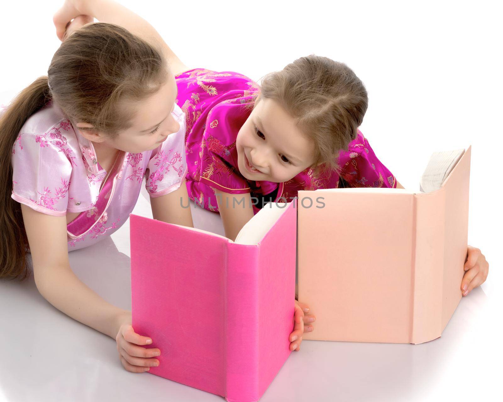 Sister girls read a book. by kolesnikov_studio