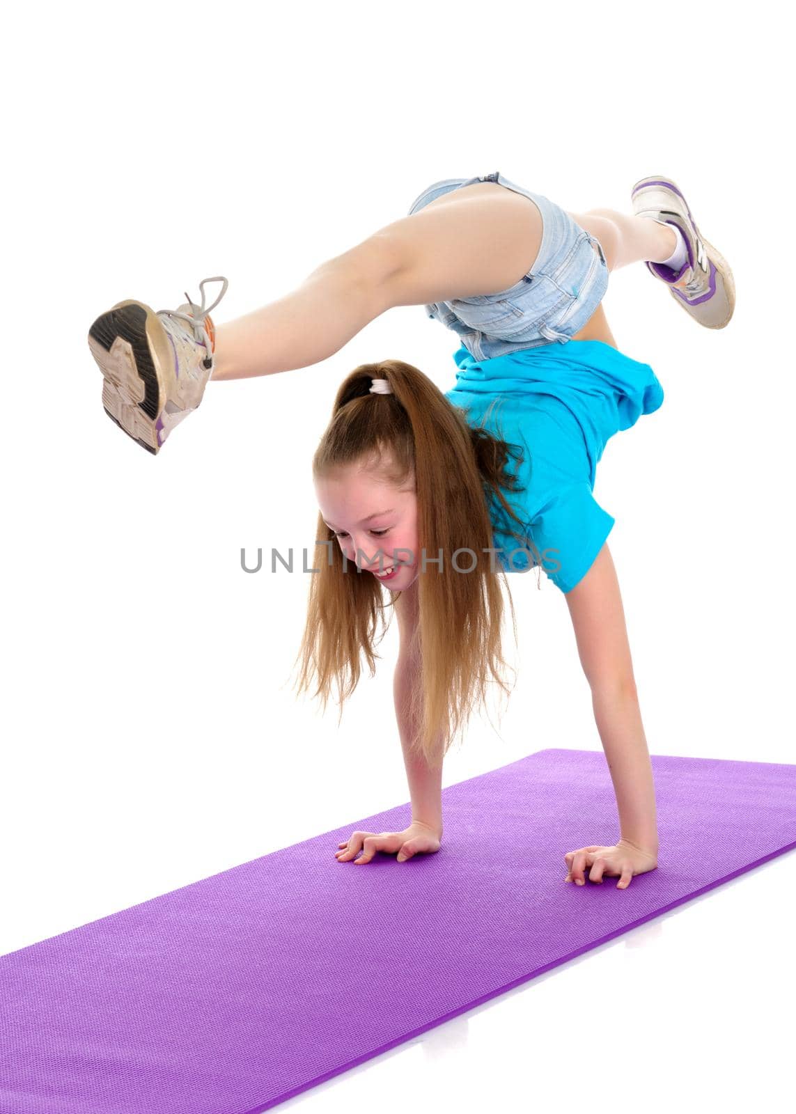 A gymnast girl stands on her hands. The concept of strength, health and sport. Isolated on white background.