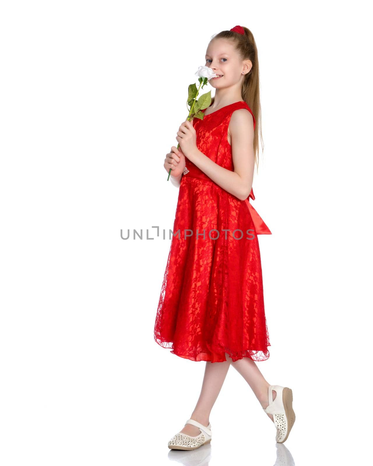 Beautiful little girl with a flower in her hands. The concept of beauty and fashion, happy childhood. Isolated on white background.