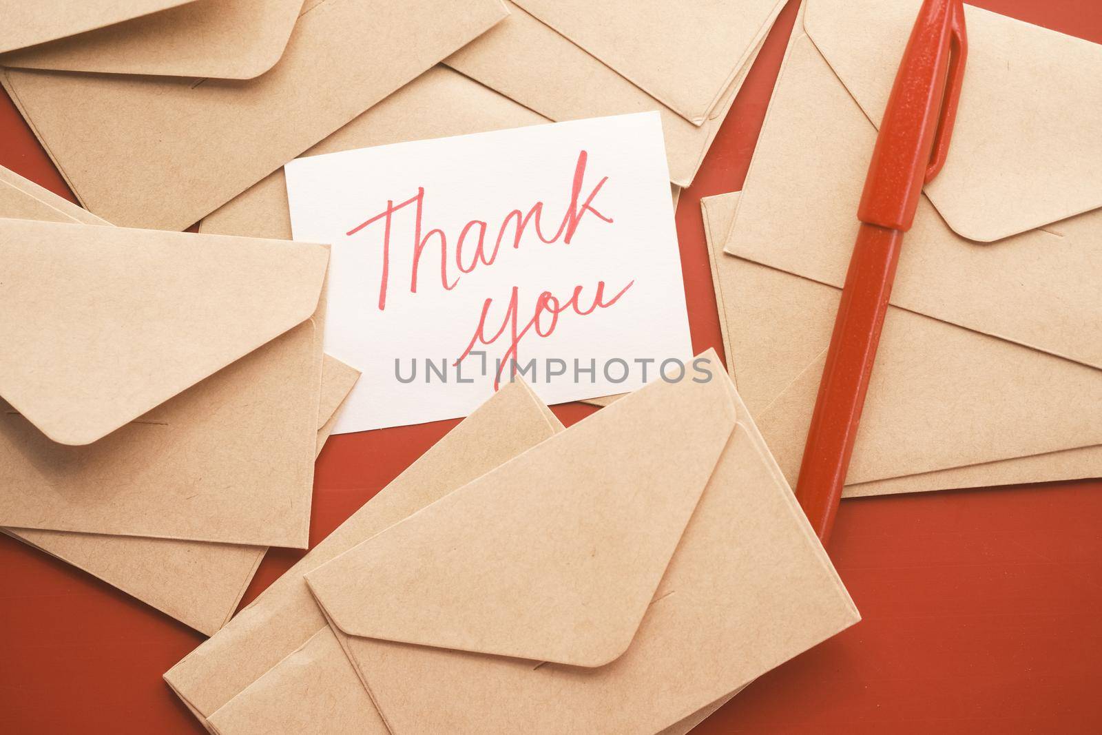 thank you message and envelope on wooden table.