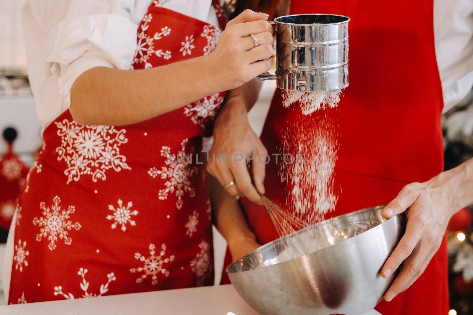 Close-up of hands pouring flour into a container for stirring dough.