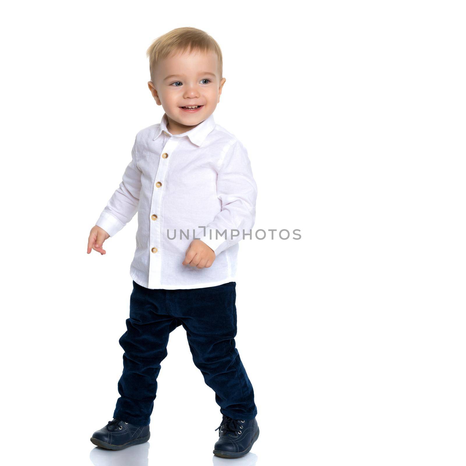 Little boy emotionally waving his hands in the studio on a white background. The concept of a happy childhood, family and people. Isolated.