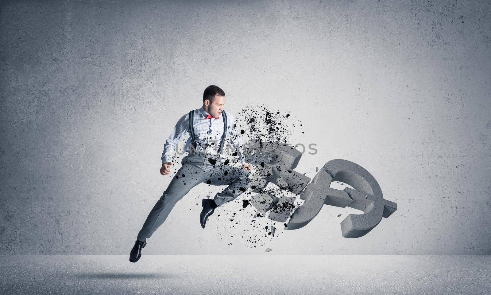 Young furious businessman jumping and crashing with kick stone dollar symbol