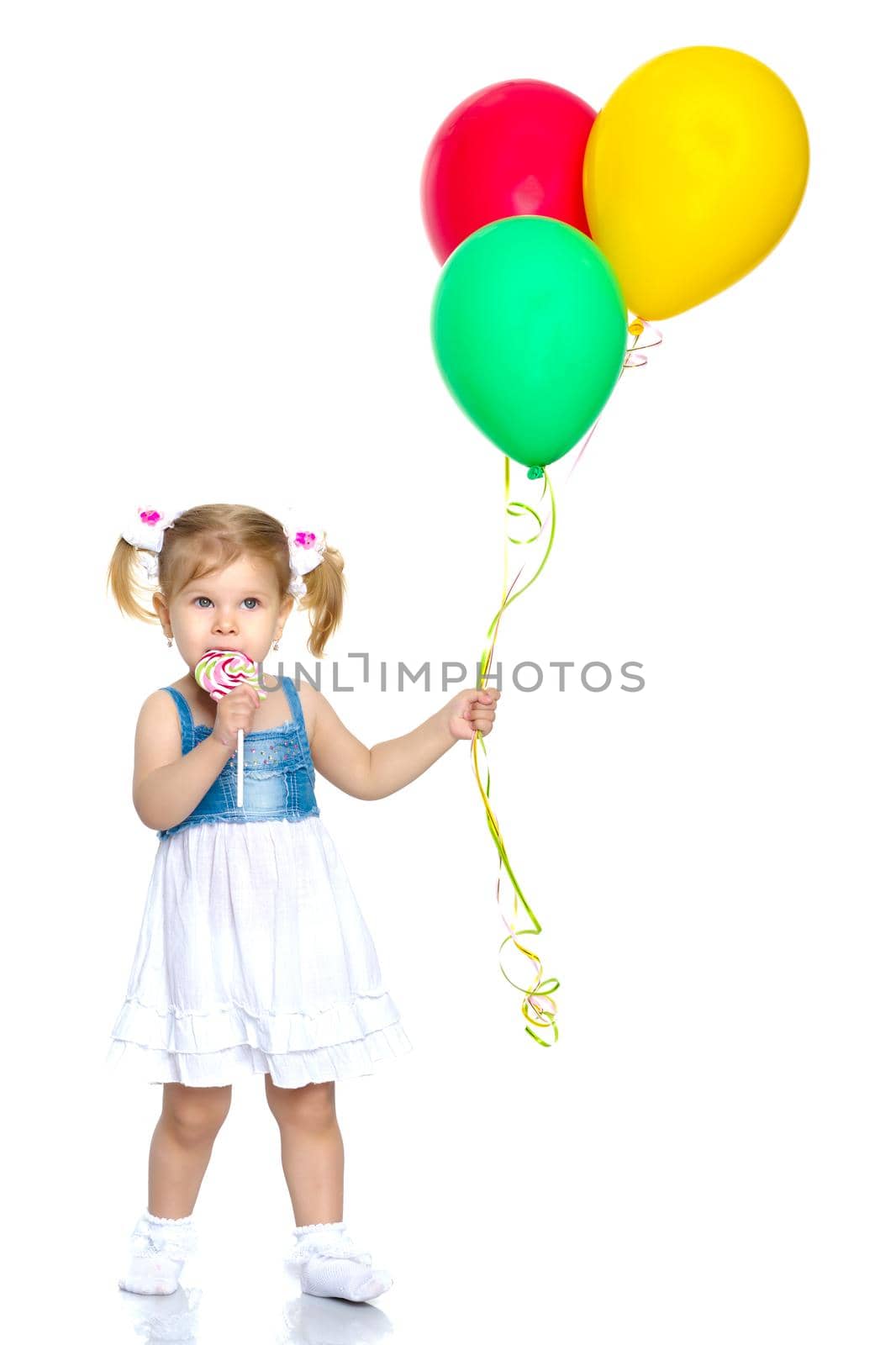 Little girl is playing with a balloon. The concept of the holiday, birthday. Isolated over white background