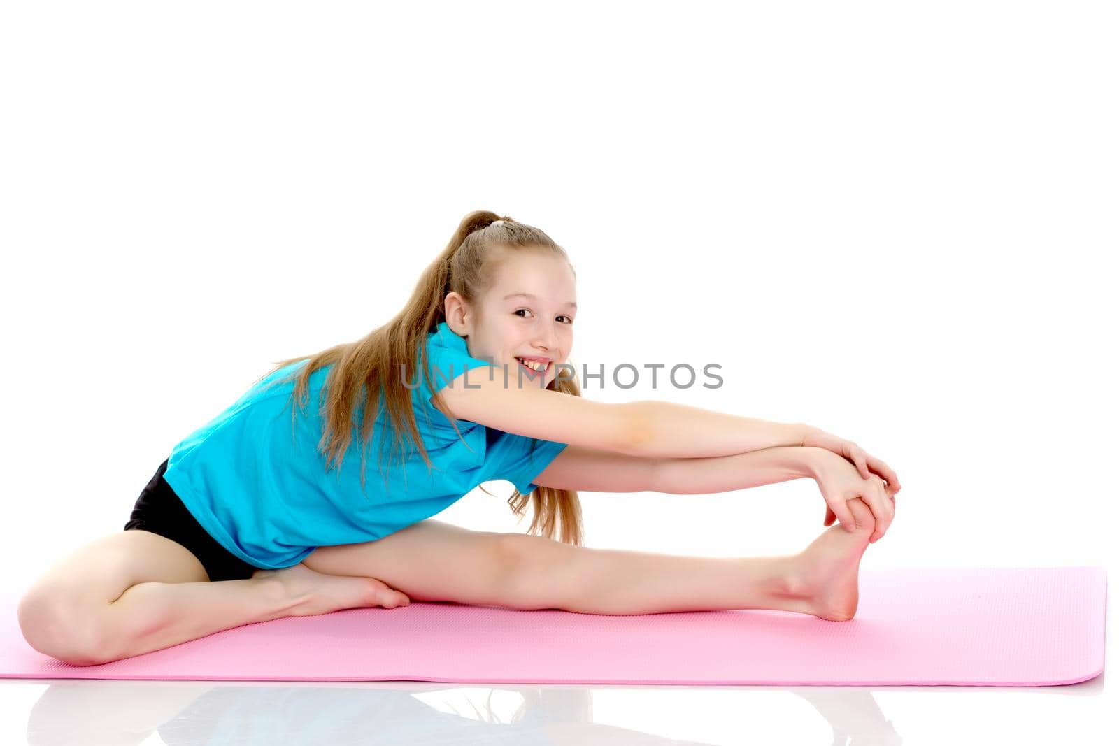 Girl gymnast performs an acrobatic element on the floor.The concept of childhood, sport, a healthy lifestyle, physical development of personality. Isolated on white background.
