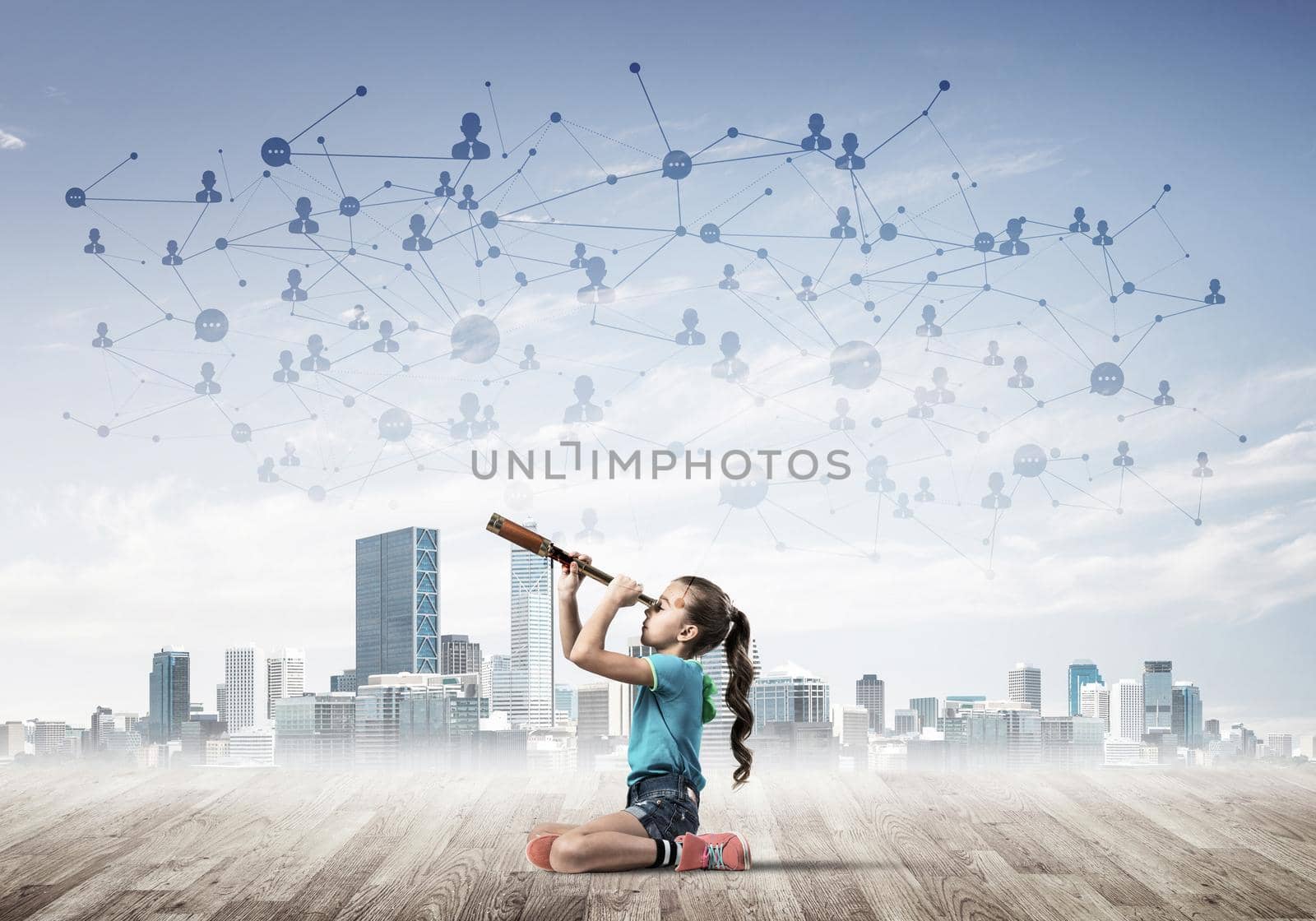 Cute kid girl sitting on wooden floor and looking in spyglass