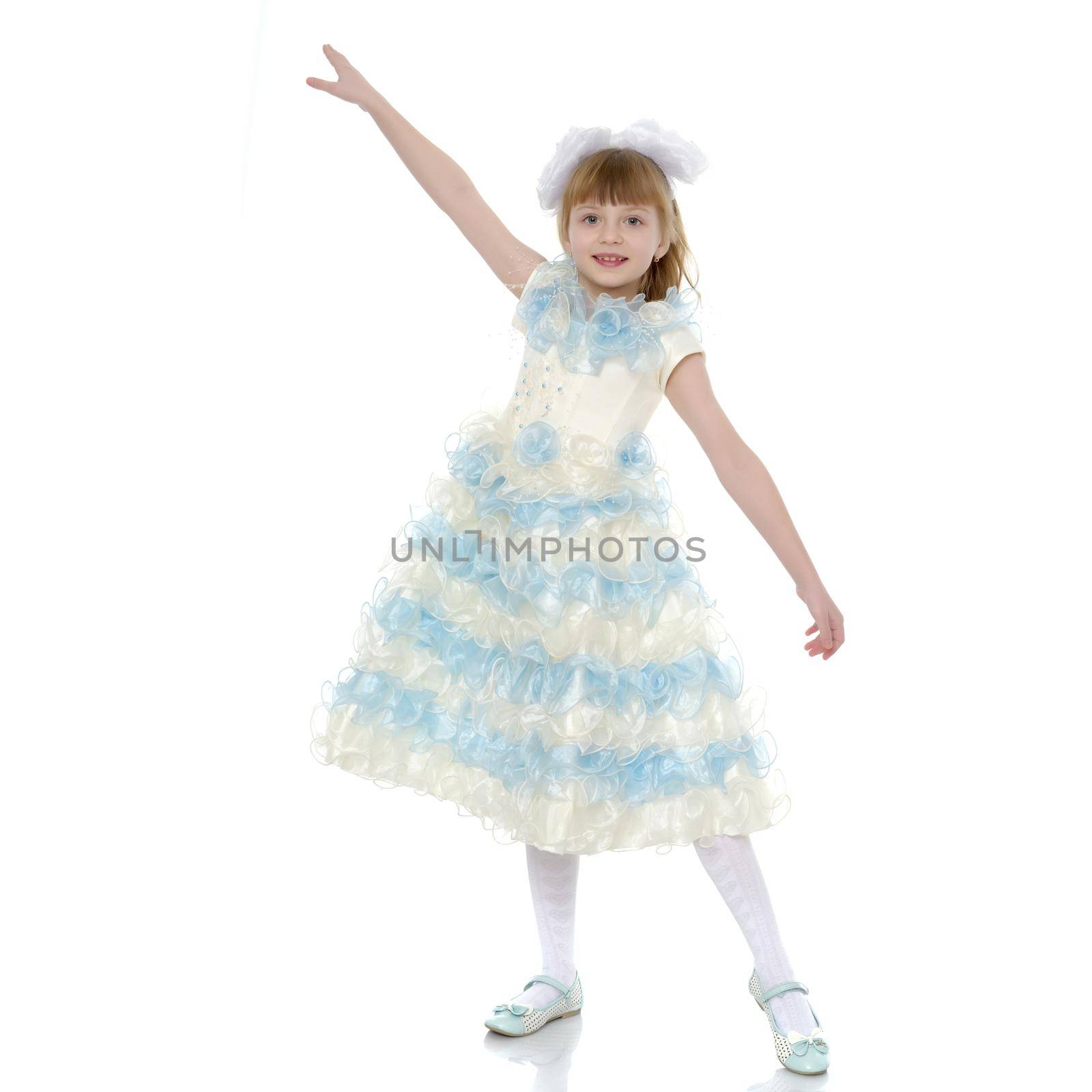 Charming little princess in a long dress. The concept of a happy childhood, beauty and fashion. Isolated on white background.