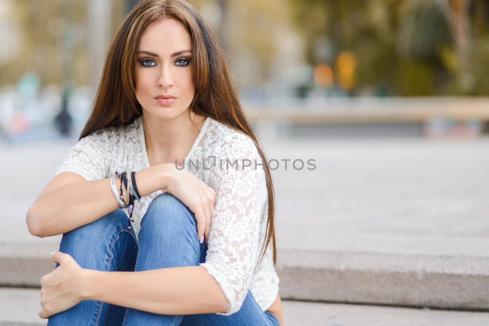Portrait of a young woman, wearing casual clothes, with long hair in urban background