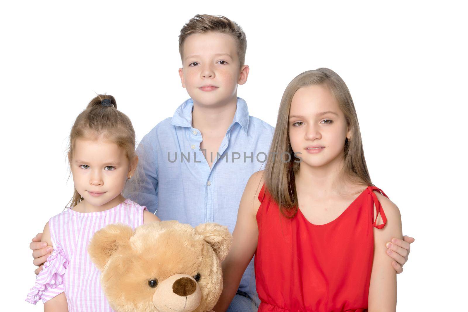 Brother and two sisters with a teddy bear. The concept of a happy childhood, a holiday, people, the harmonious development of a child in the family. Isolated on white background.