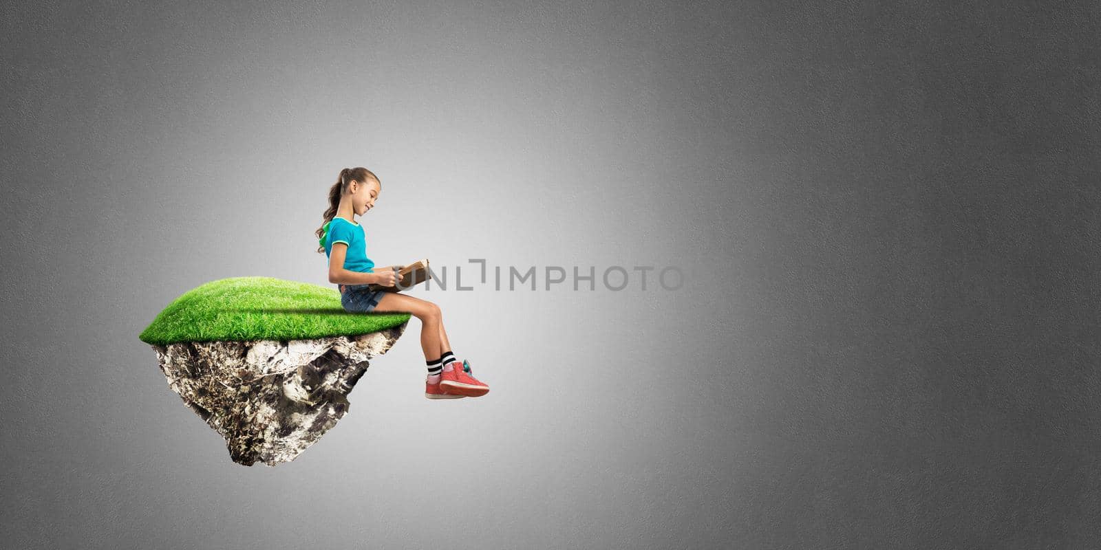 Cute kid girl sitting on floating island against concrete background