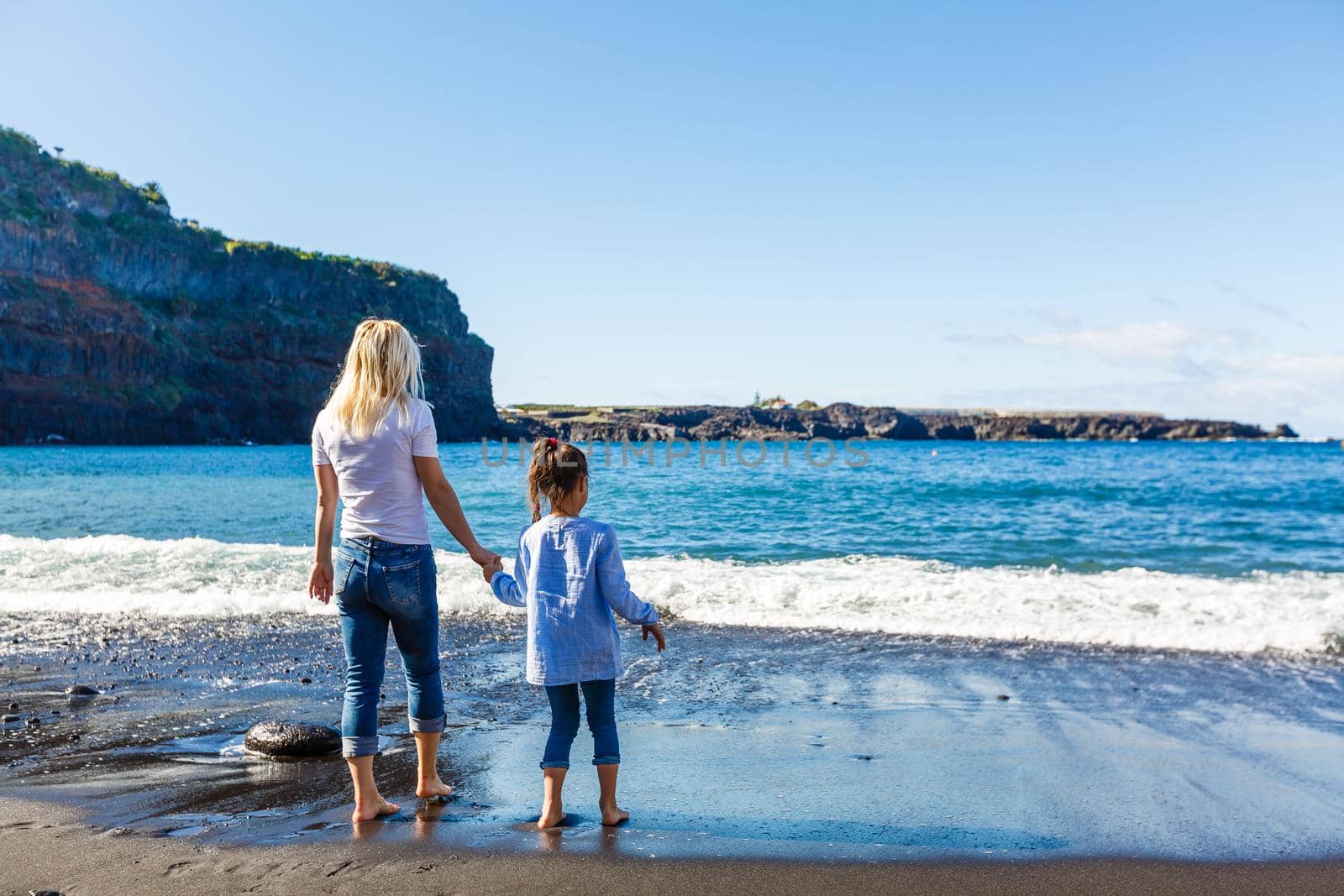 Family holiday on Tenerife, Spain. Mother with children outdoors on ocean. Portrait travel tourists - mom with kids. Positive human emotions, active lifestyles. Happy young family on sea beach