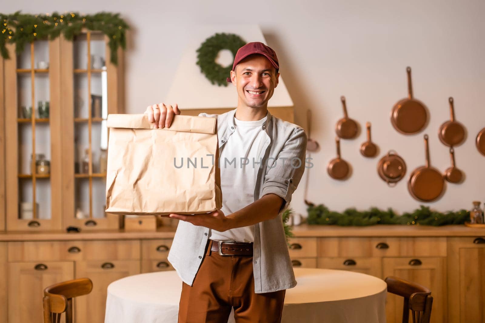 Young delivery man holding and carrying a cardbox. Buy food online in quarantine concept.