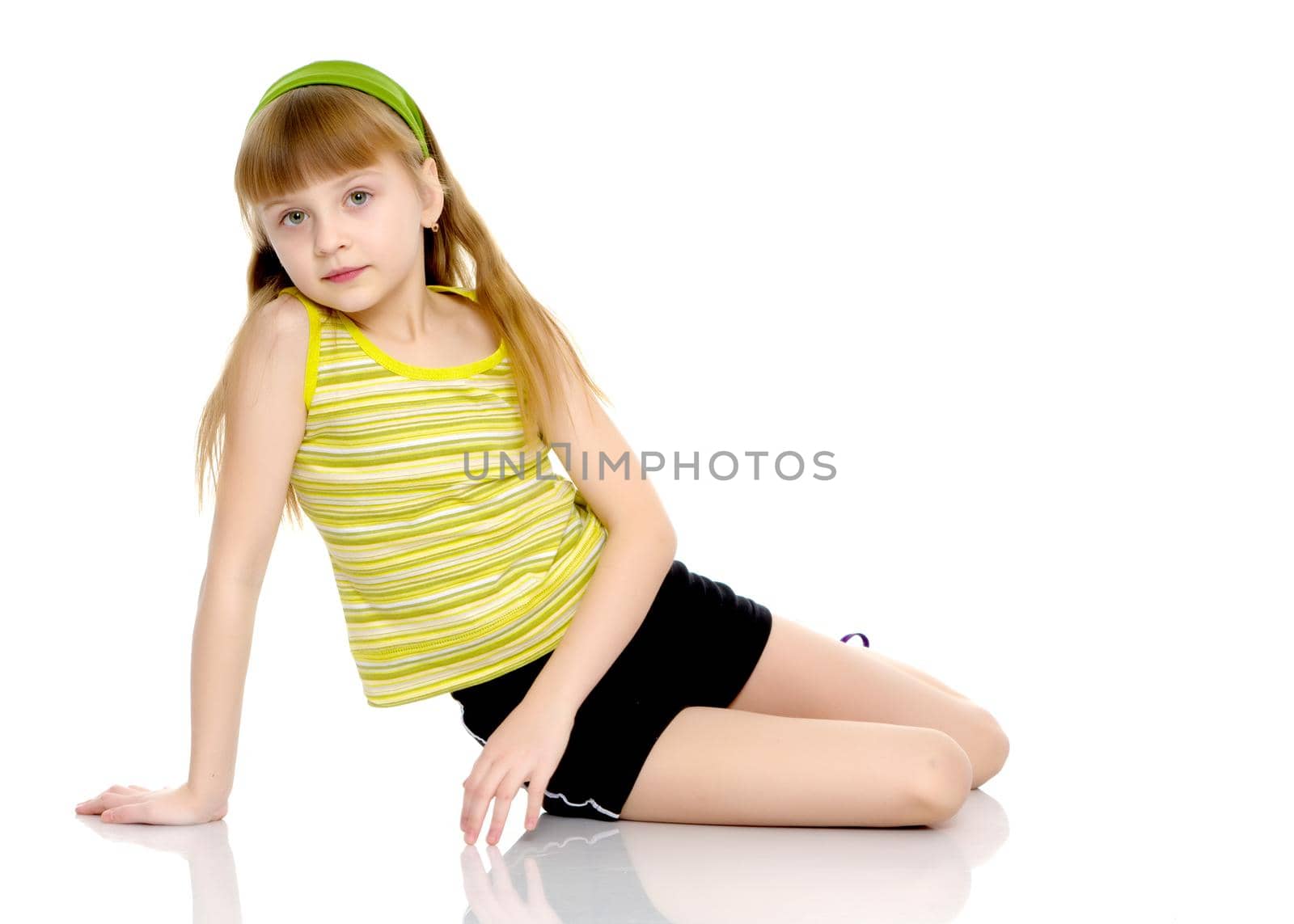 A nice little girl is performing gymnastic exercises. Concept of a healthy lifestyle, sport and fitness. Isolated on white background.