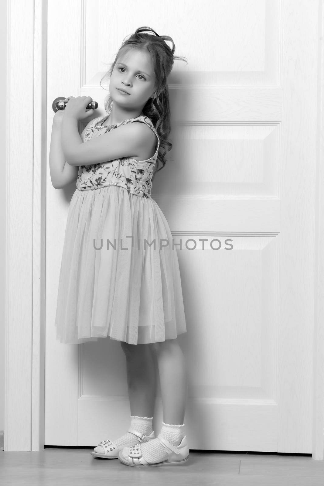 A little girl is standing by the door. by kolesnikov_studio