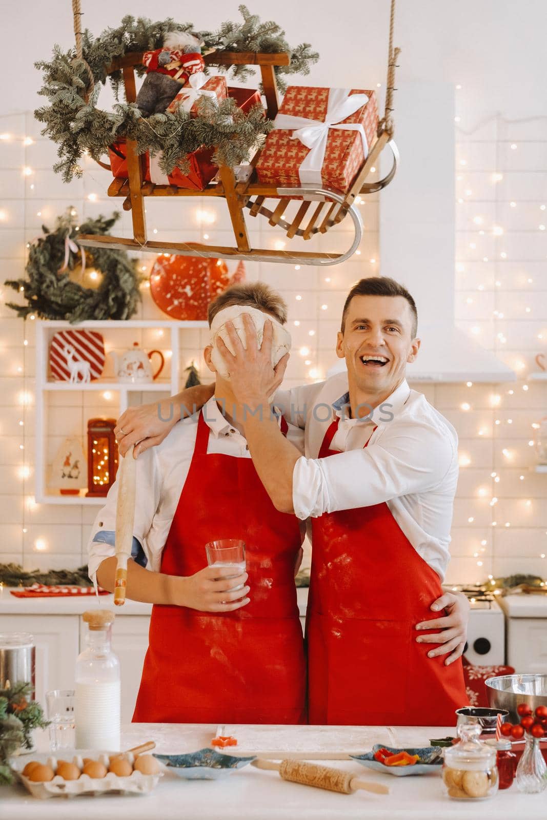 Father and son in the Christmas kitchen prepare dough for making cookies.