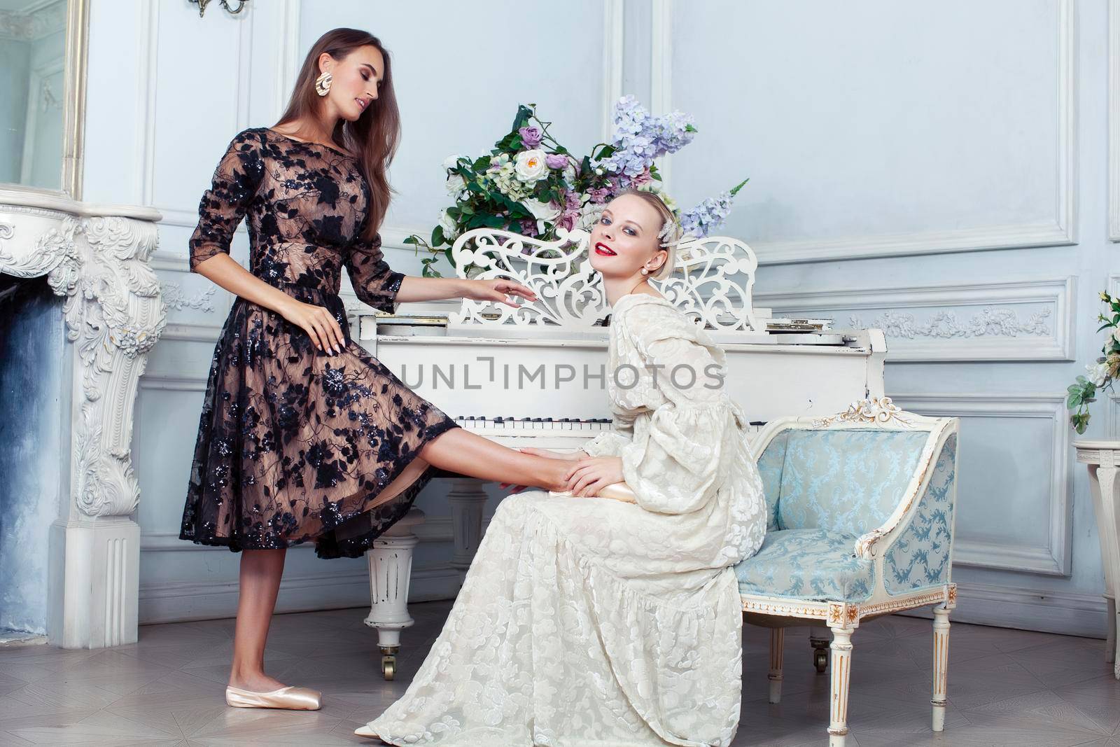 young pretty brunette ballet dancer at piano with blond woman in luxury royal interior, lifestyle rich people concept closeup