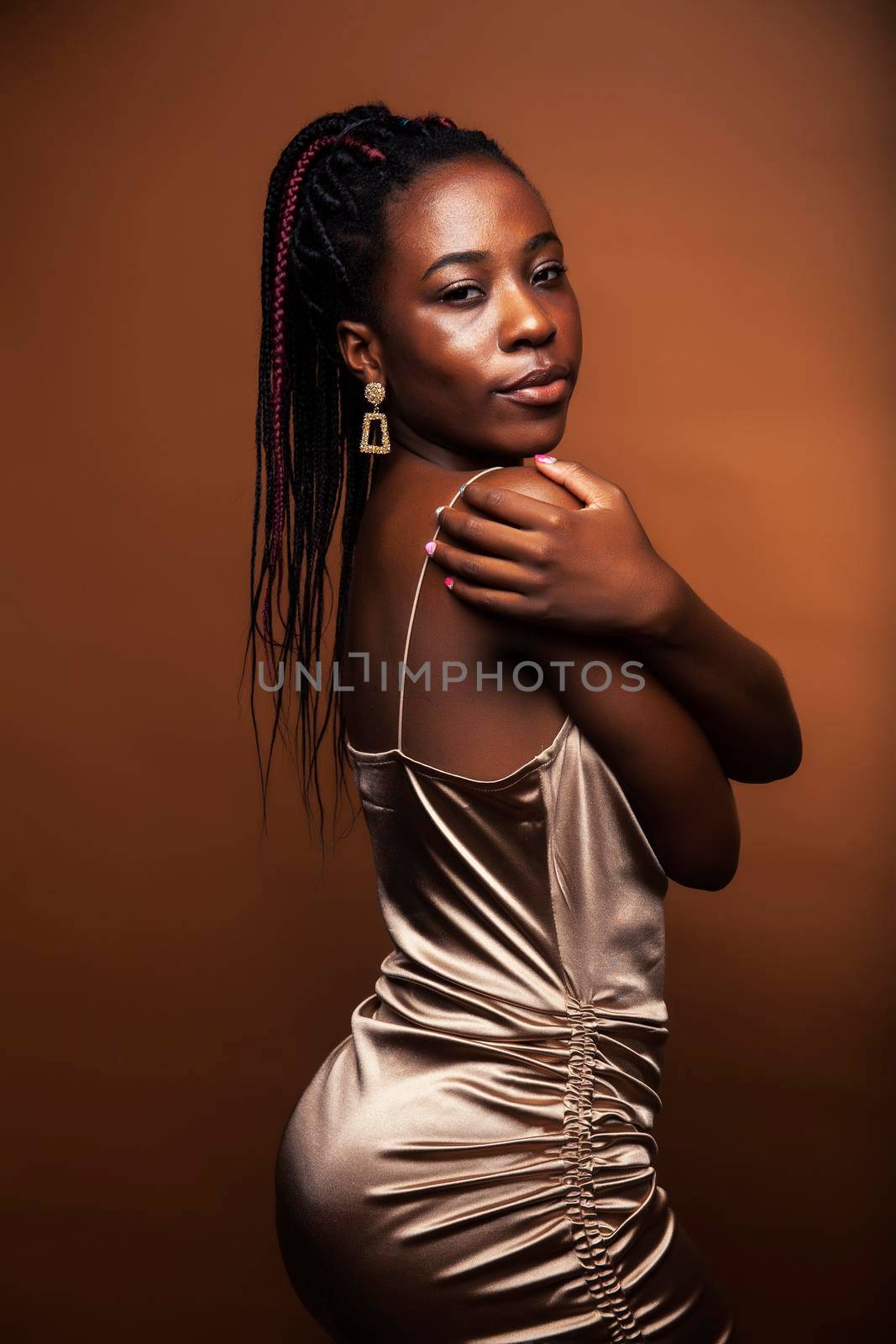 pretty young african american woman posing cheerful gesturing on brown background, lifestyle people concept closeup