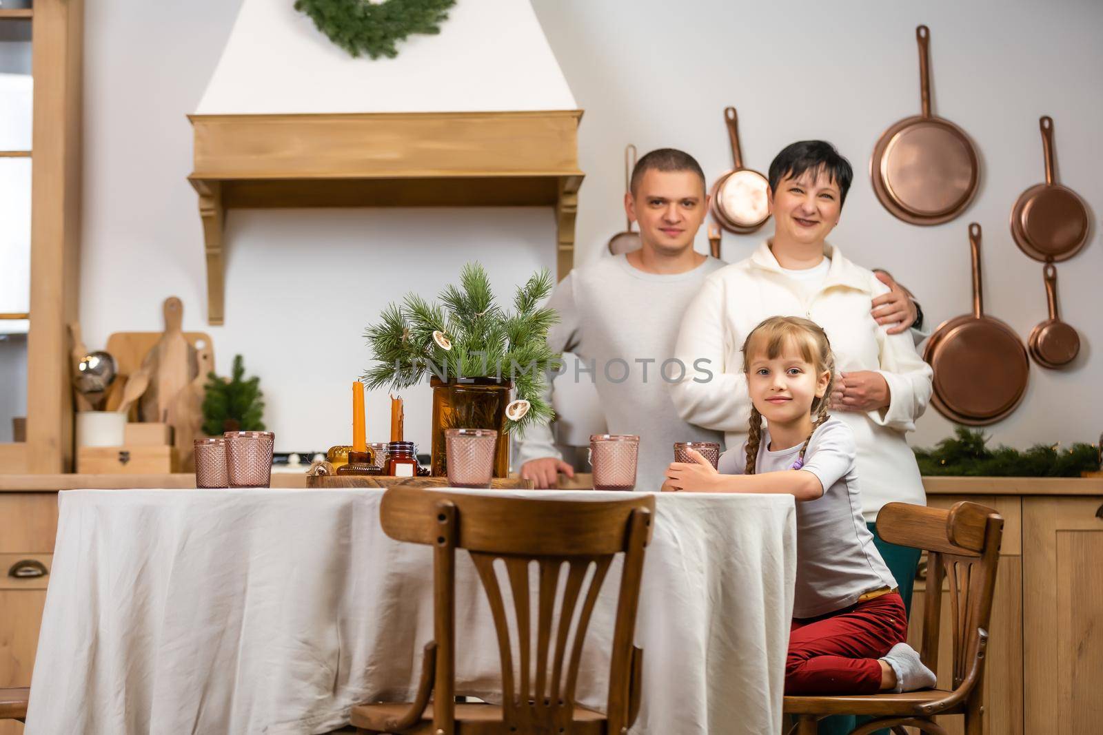 holidays, family and celebration concept - happy mother, father and little daughter having christmas dinner at home by Andelov13