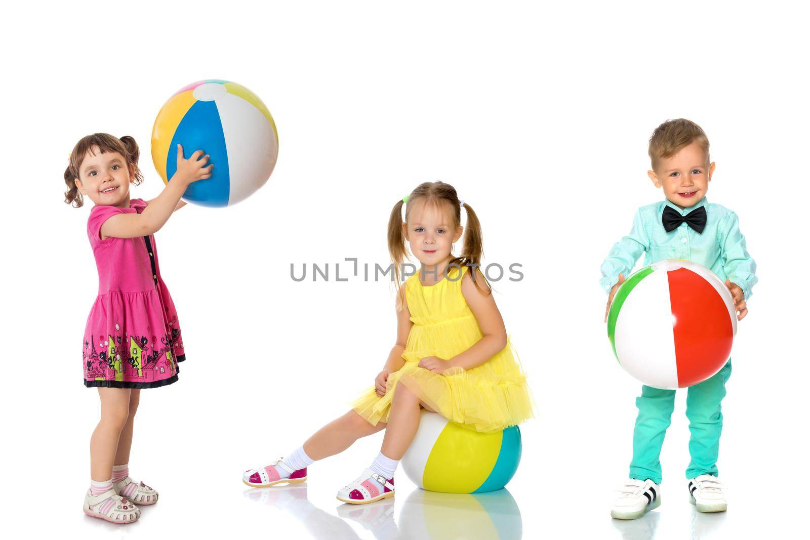 Funny little kids are playing with the ball. Group collage of several models. Concept summer, game, happy childhood. Isolated on white background.