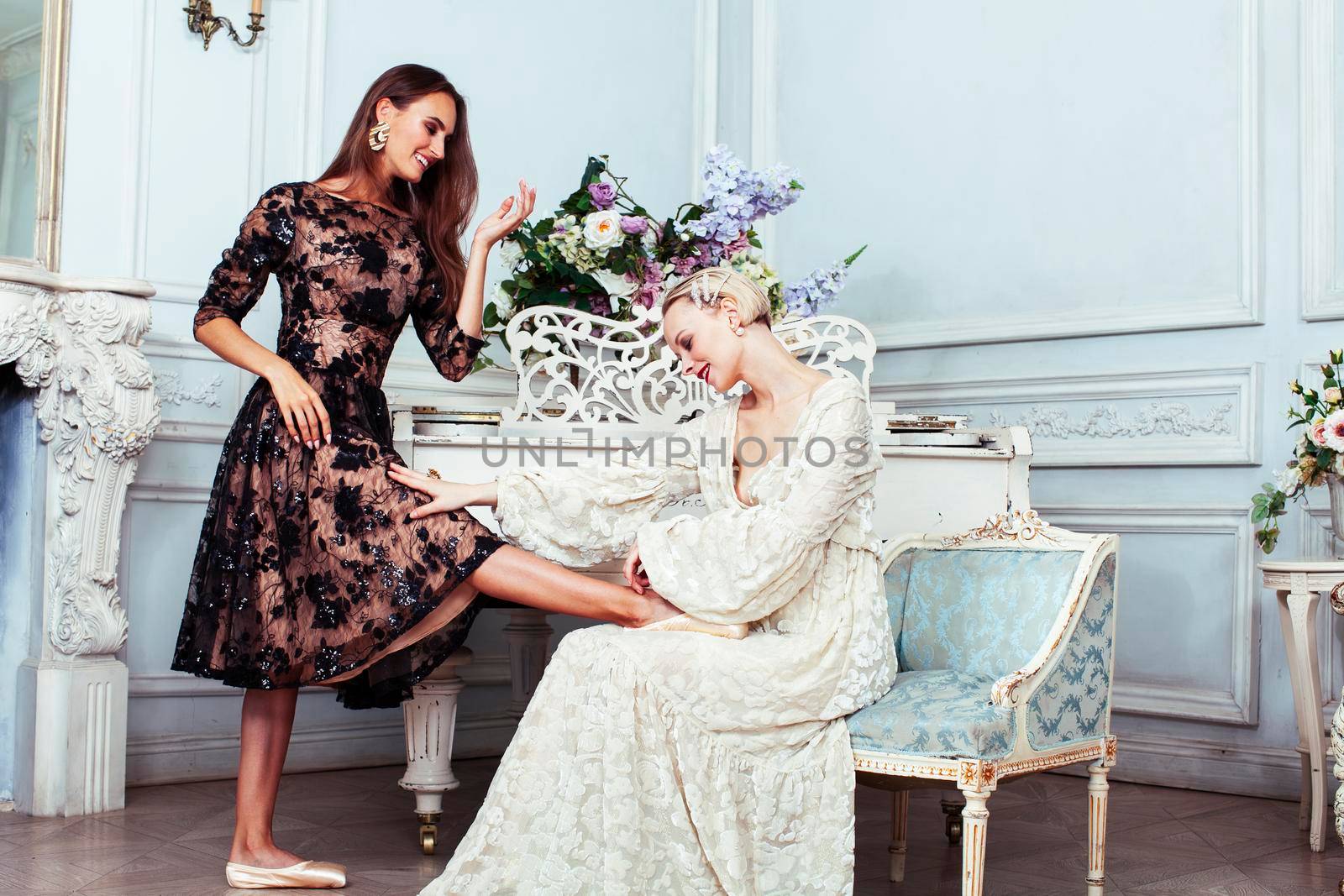 young pretty brunette ballet dancer at piano with blond woman in luxury royal interior, lifestyle rich people concept closeup