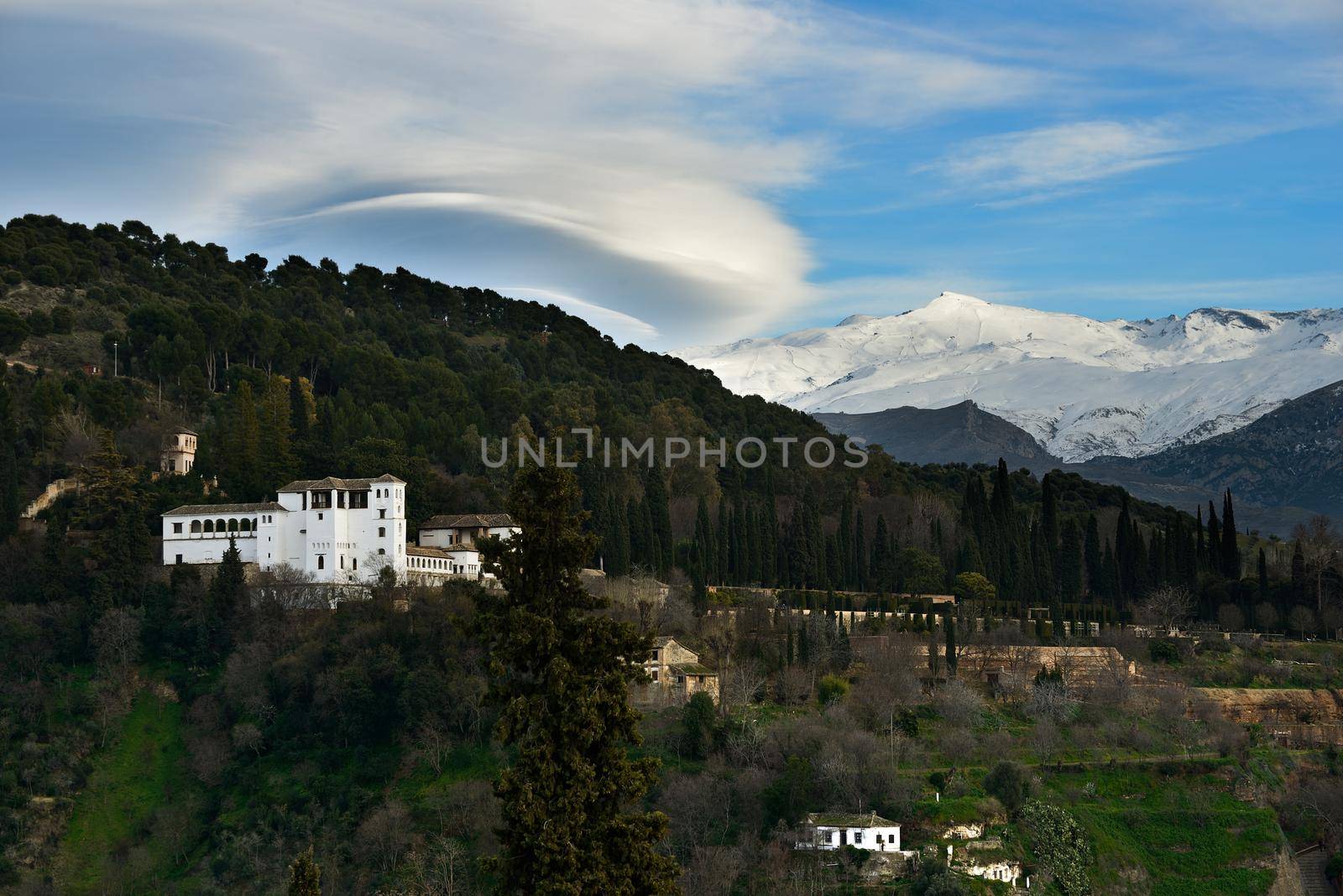 Aerial view of Alhambra and snowing Sierra Nevada mountains under a lenticular cloud