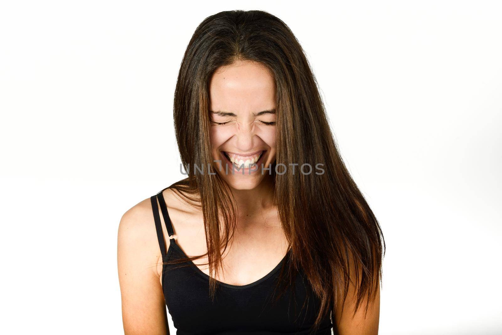 Beautiful young woman without make-up laughing. Beautiful girl with green eyes, model of fashion wearing black tank top on white background.