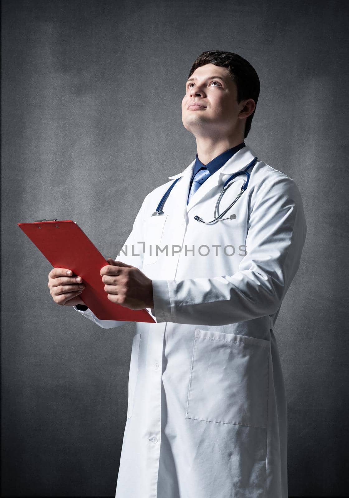 Doctor with tablet for documents, scans documents against the background of the wall