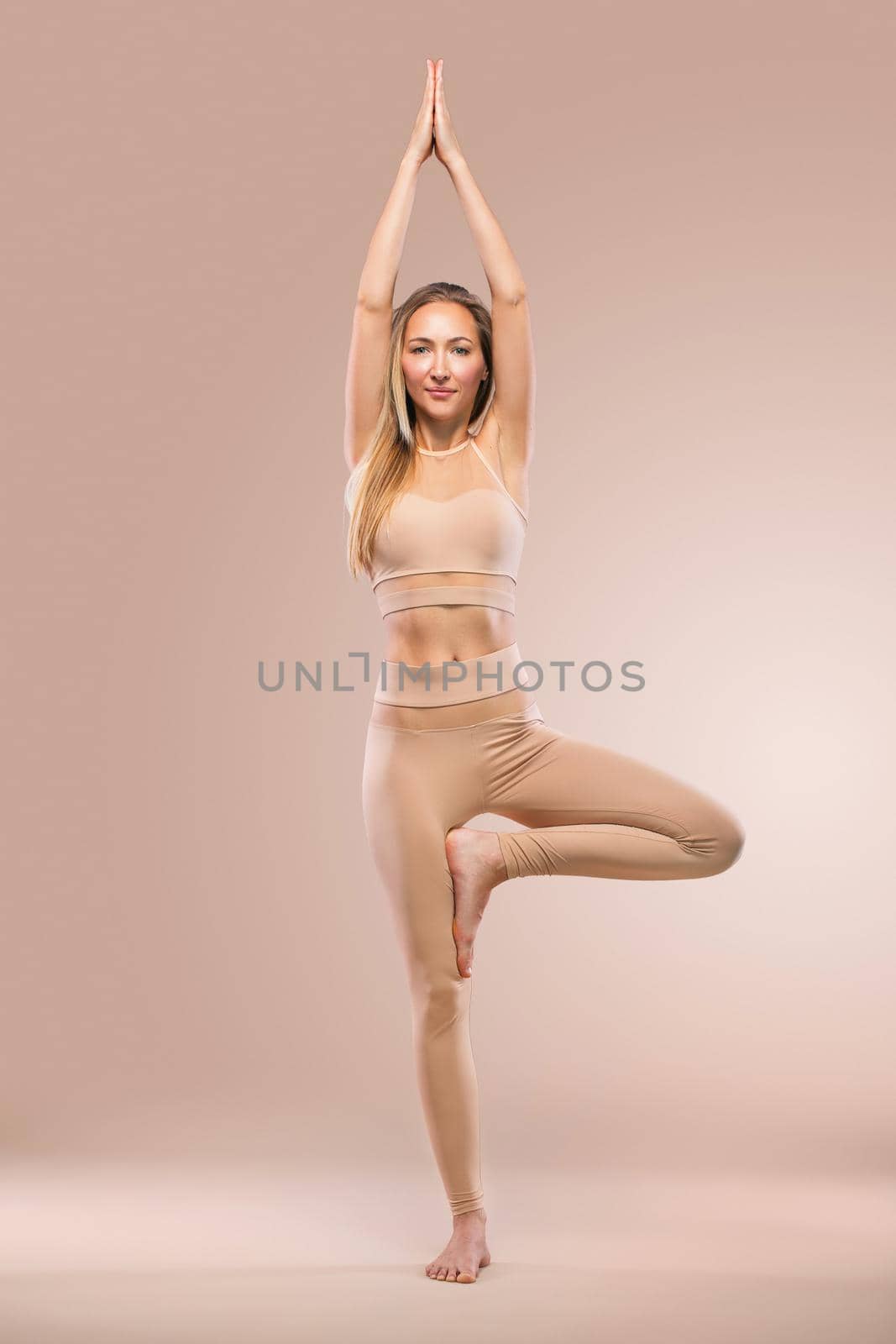 Indoor Yoga Classes. Sports recreation. Beautiful young woman in asana pose. Individual sports. Nude sportswear. by MikeOrlov