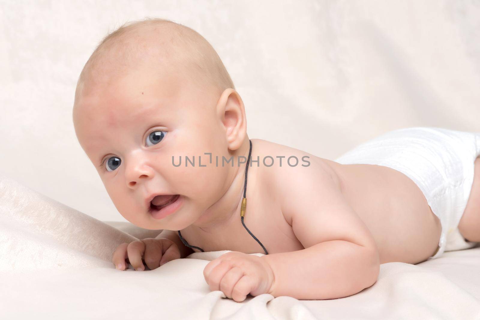 A charming baby looks at the camera. by kolesnikov_studio