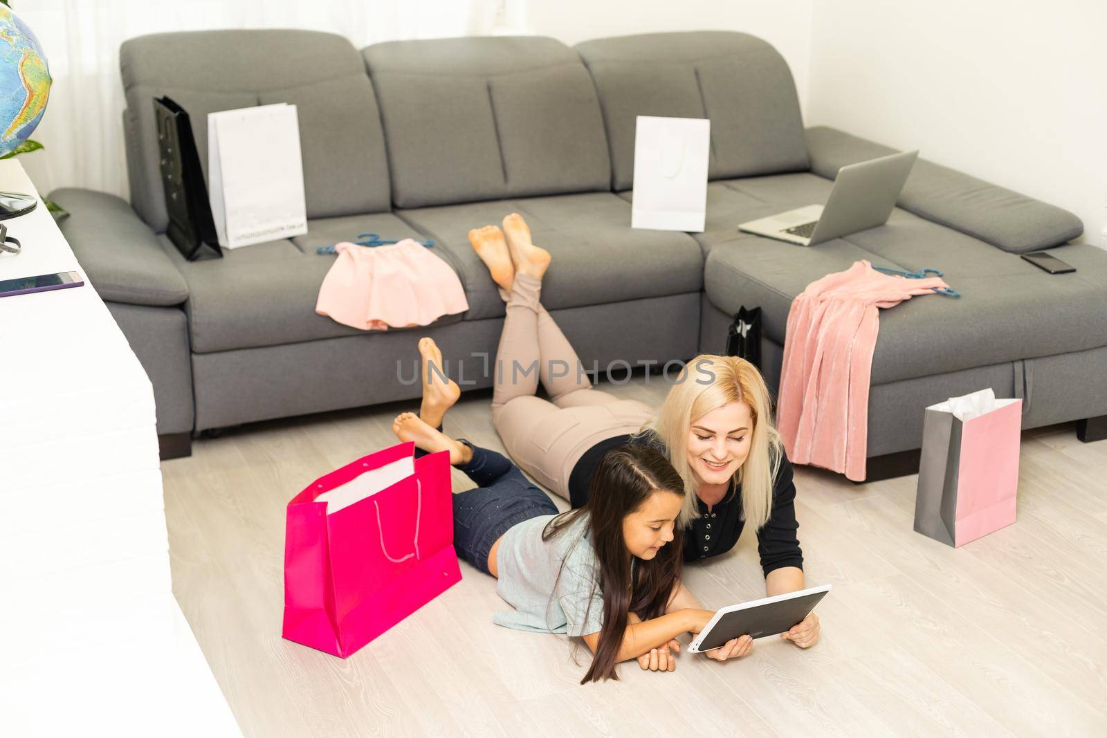 Mother and daughter is using tablet for buying thing online black Friday by Andelov13