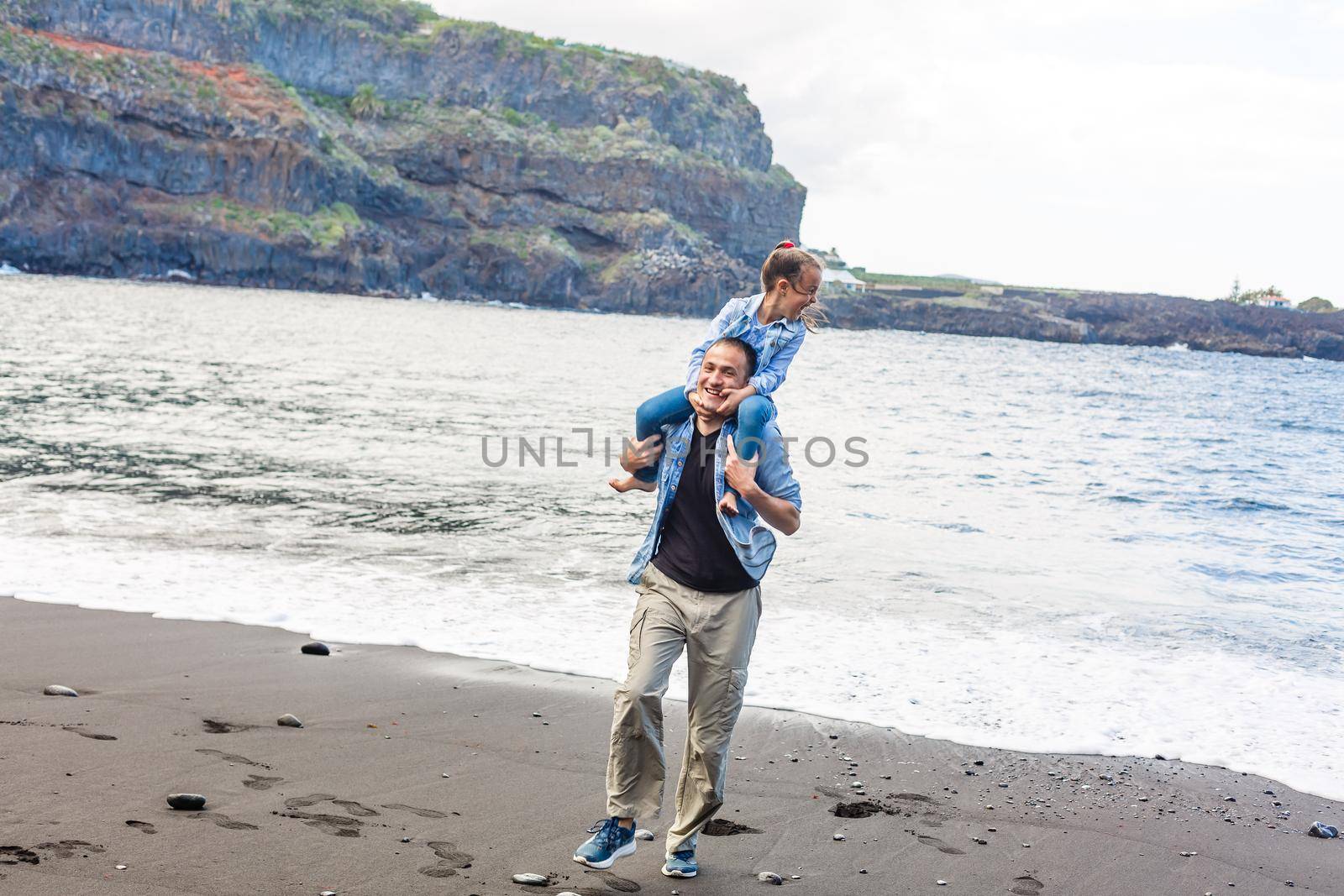 Happy family standing on the beach on the dawn time