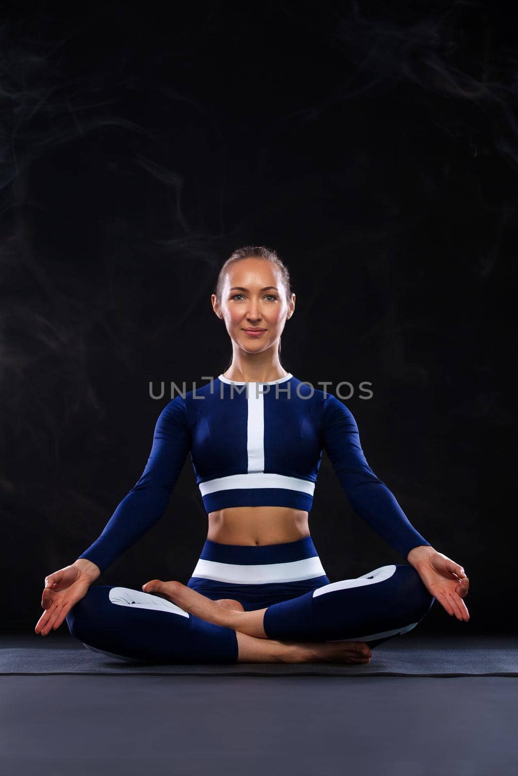 Portrait of a beautiful young woman sitting in yoga pose