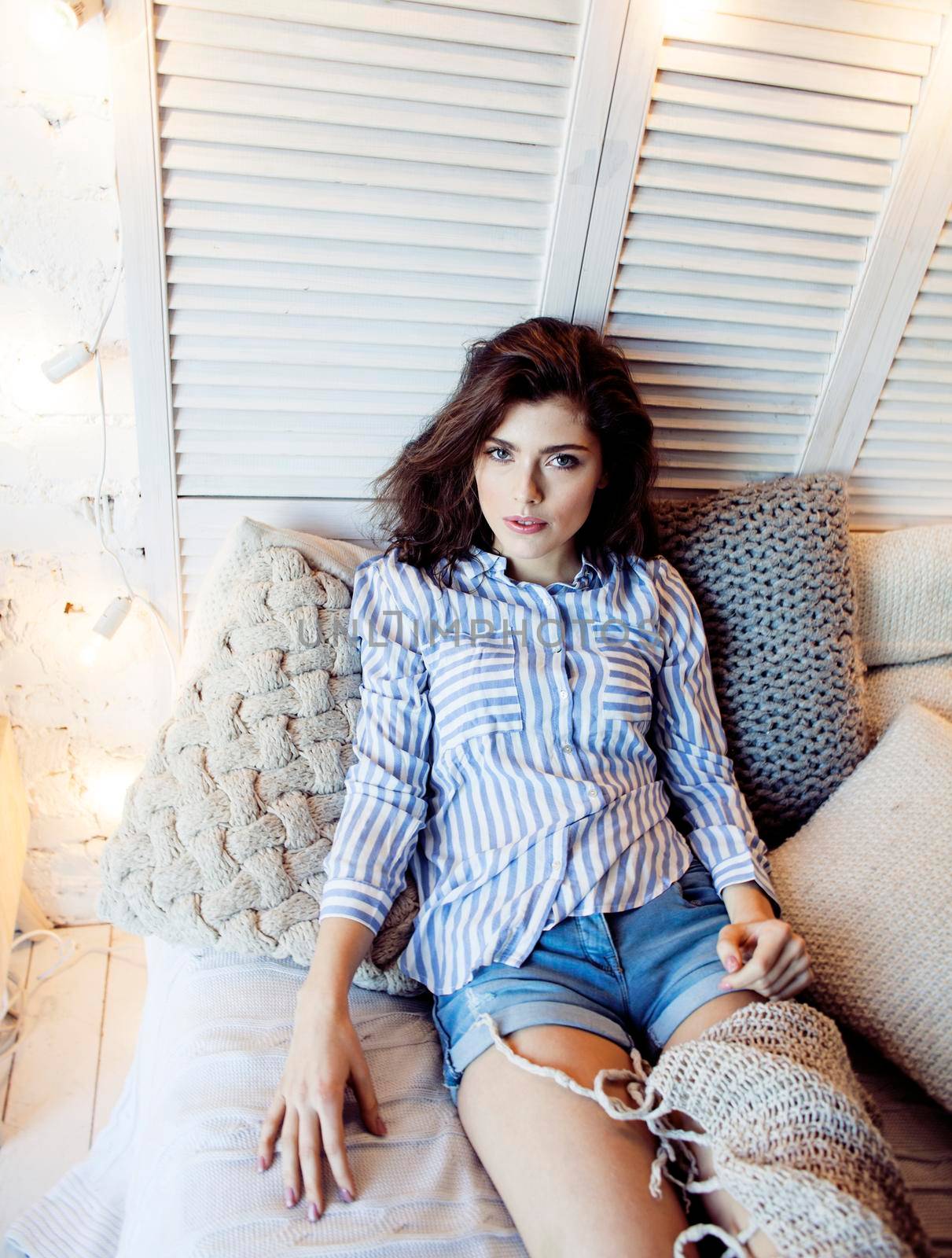 young pretty brunette woman in her bedroom sitting at window, happy smiling lifestyle people concept close up