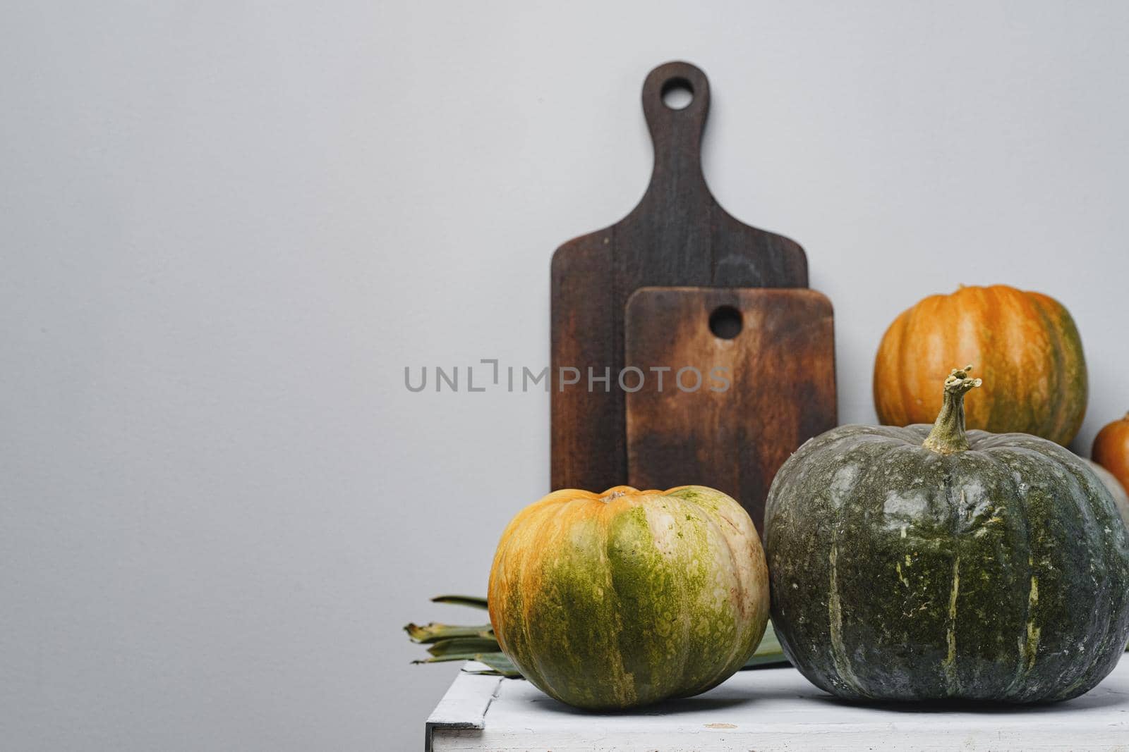 Pumpkins on kitchen table against grey wall close up