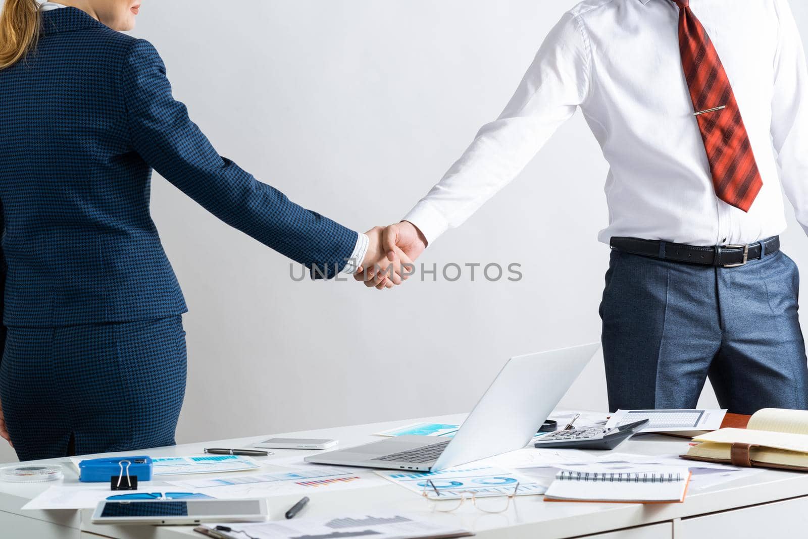 Businessman and woman handshaking after good deal by adam121