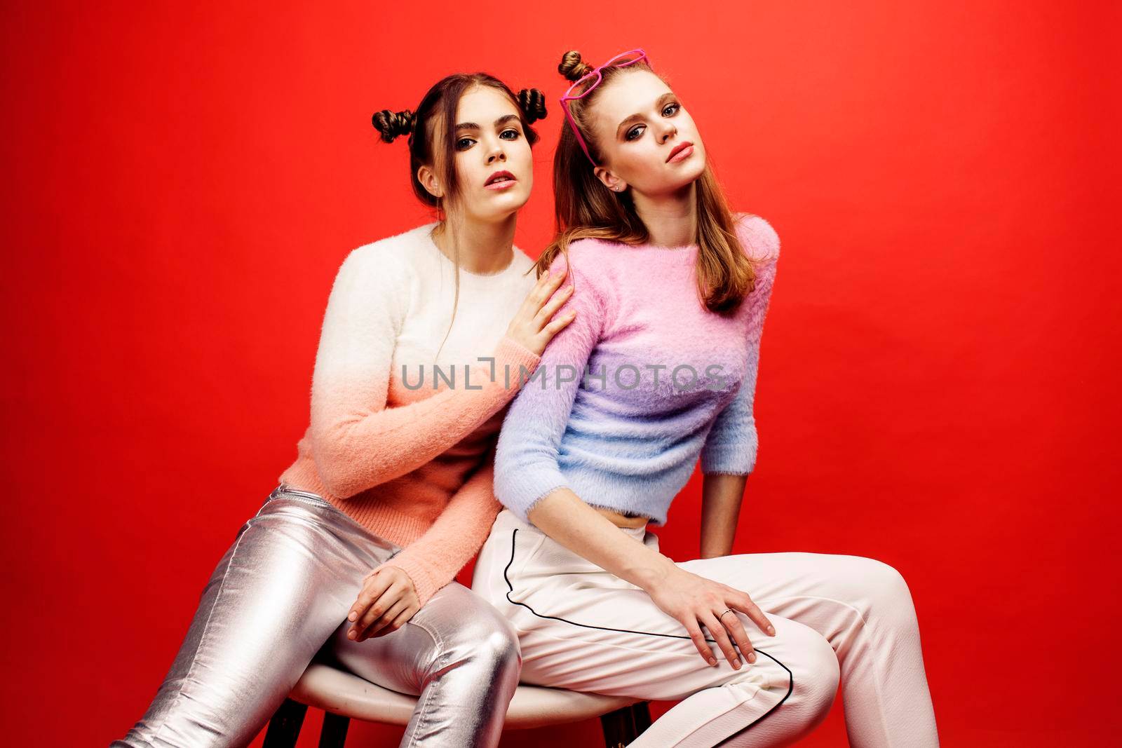 two best friends teenage girls together having fun, posing emotional on red background, besties happy smiling, lifestyle people concept close up