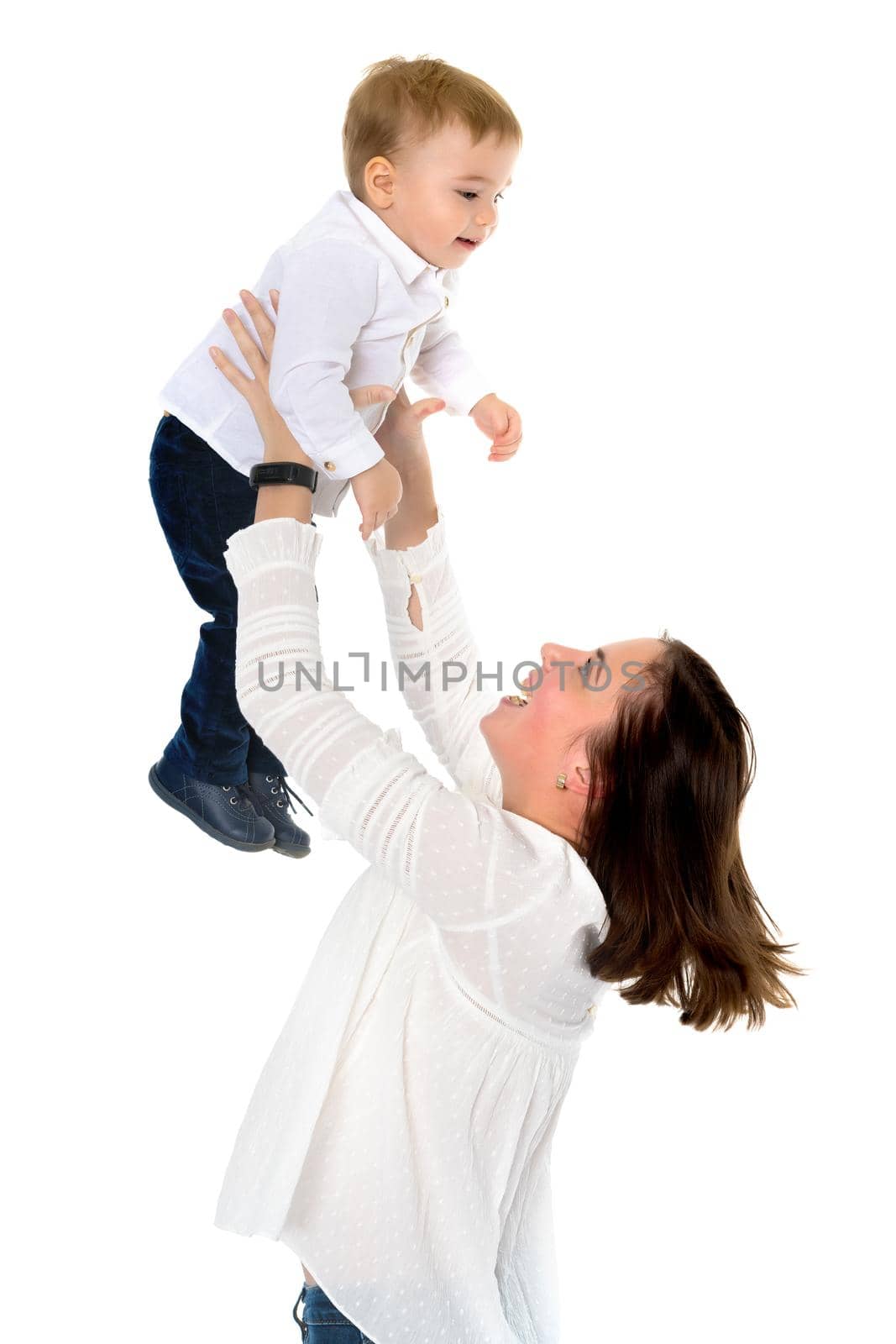 Happy smiling loving mother and her baby is playing on a white background. Mom throws the baby in her arms. Isolated.
