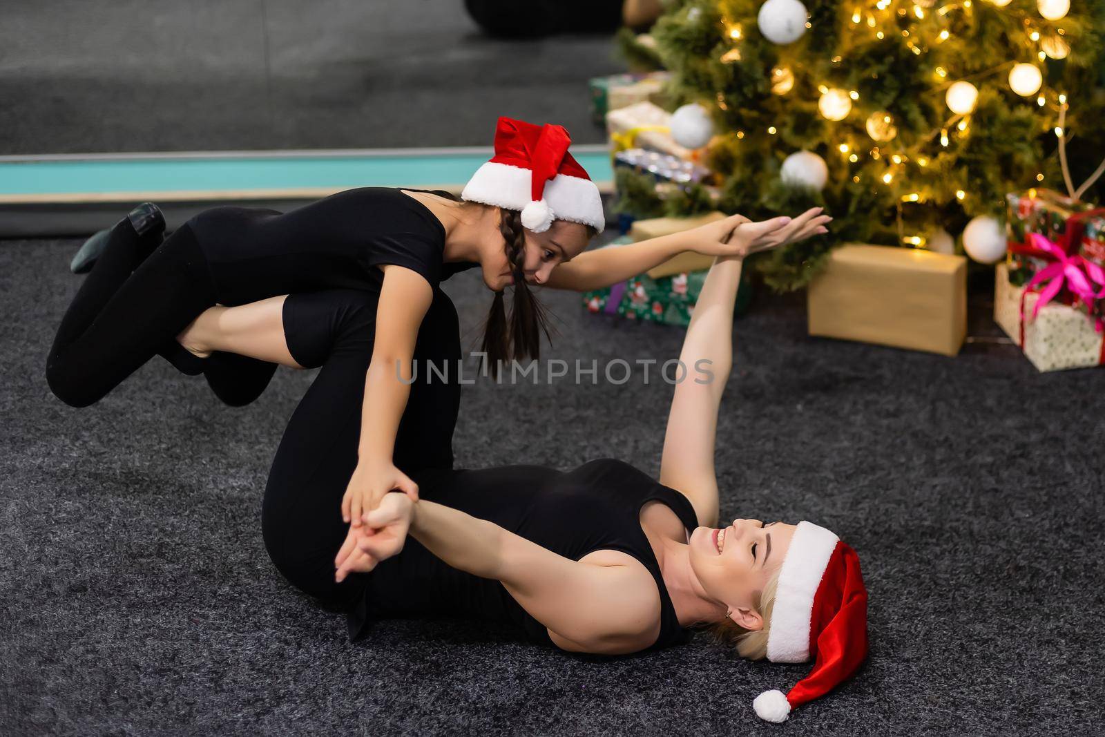 woman with child doing yoga in Christmas hats