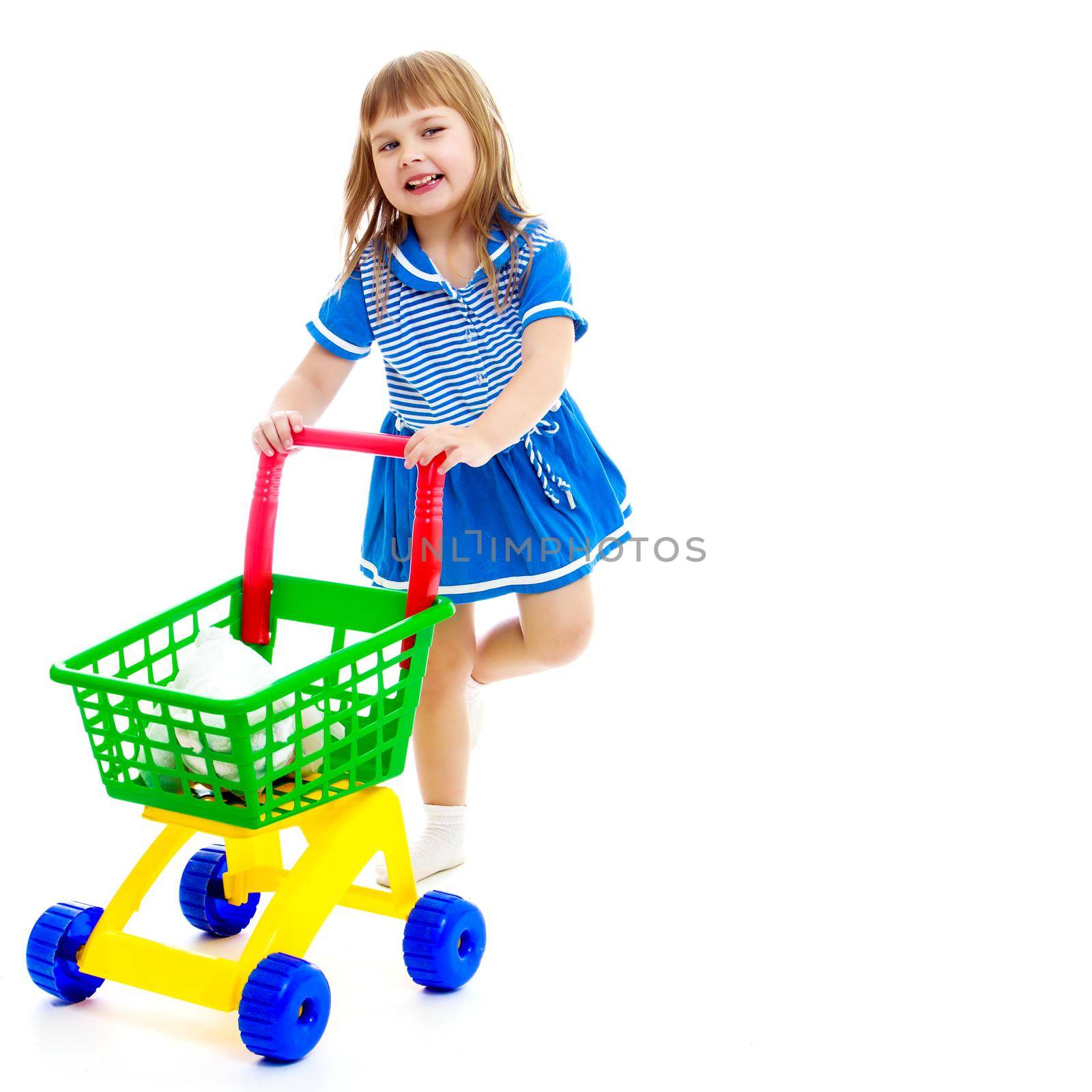 A cute little girl with a cart at the supermarket is shopping. The concept of advertising and selling goods and services. Isolated on white background.