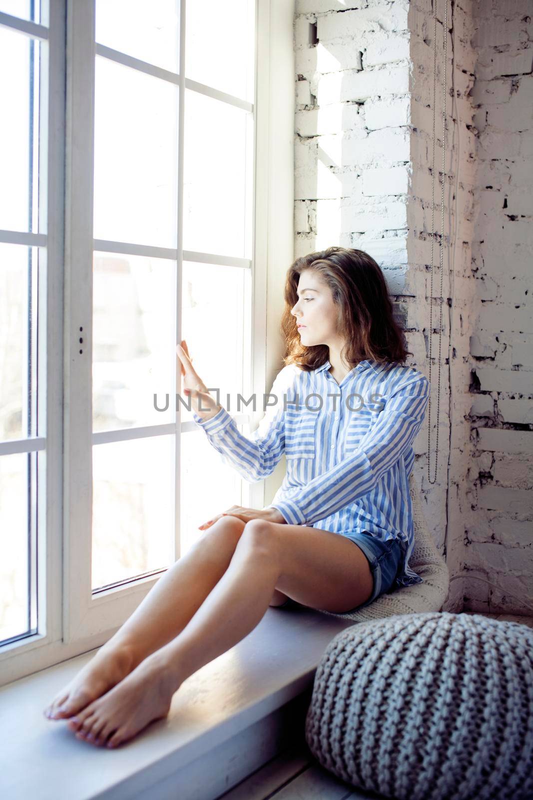 young pretty brunette woman in her bedroom sitting at window, happy smiling lifestyle people concept close up