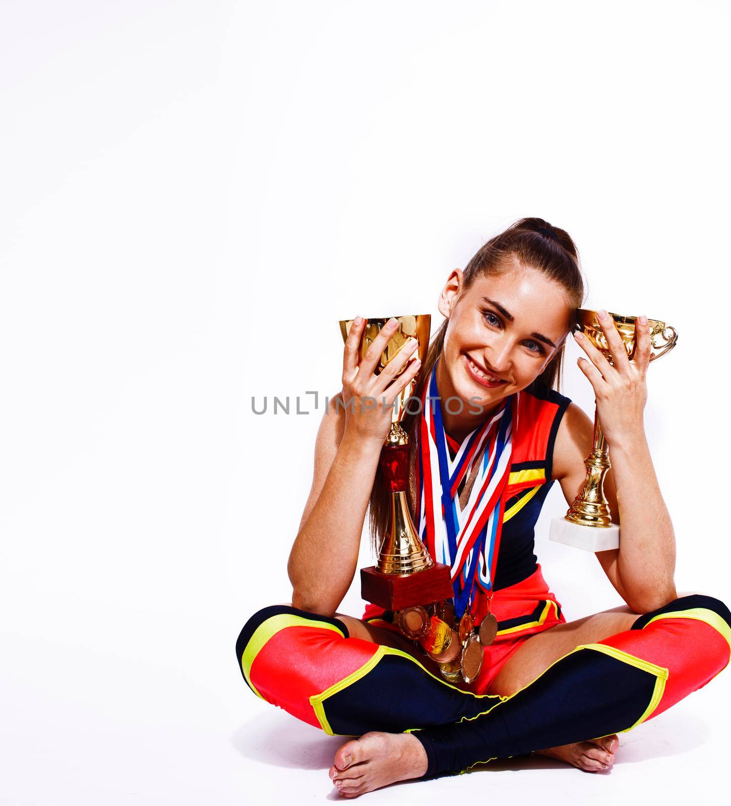 young smiling cheerleader girl with golden cups and price medals isolated on white background, lifestyle sport people concept by JordanJ