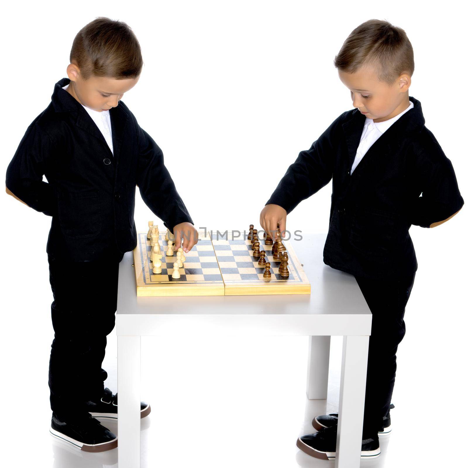 Two brothers are playing chess at home. Game, education, lifestyle concept.Isolated on white background