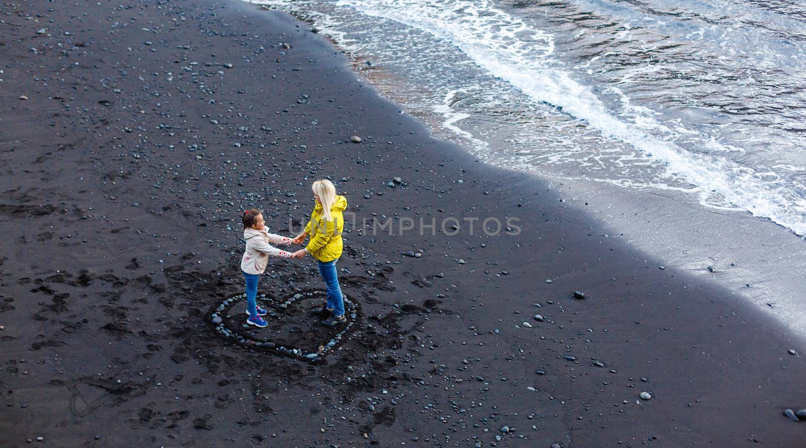 Family holiday on Tenerife, Spain, Europe. Mother and daughter outdoors on ocean. Portrait travel tourists - mom with child. Positive human emotions, active lifestyles. Happy young family on sea beach