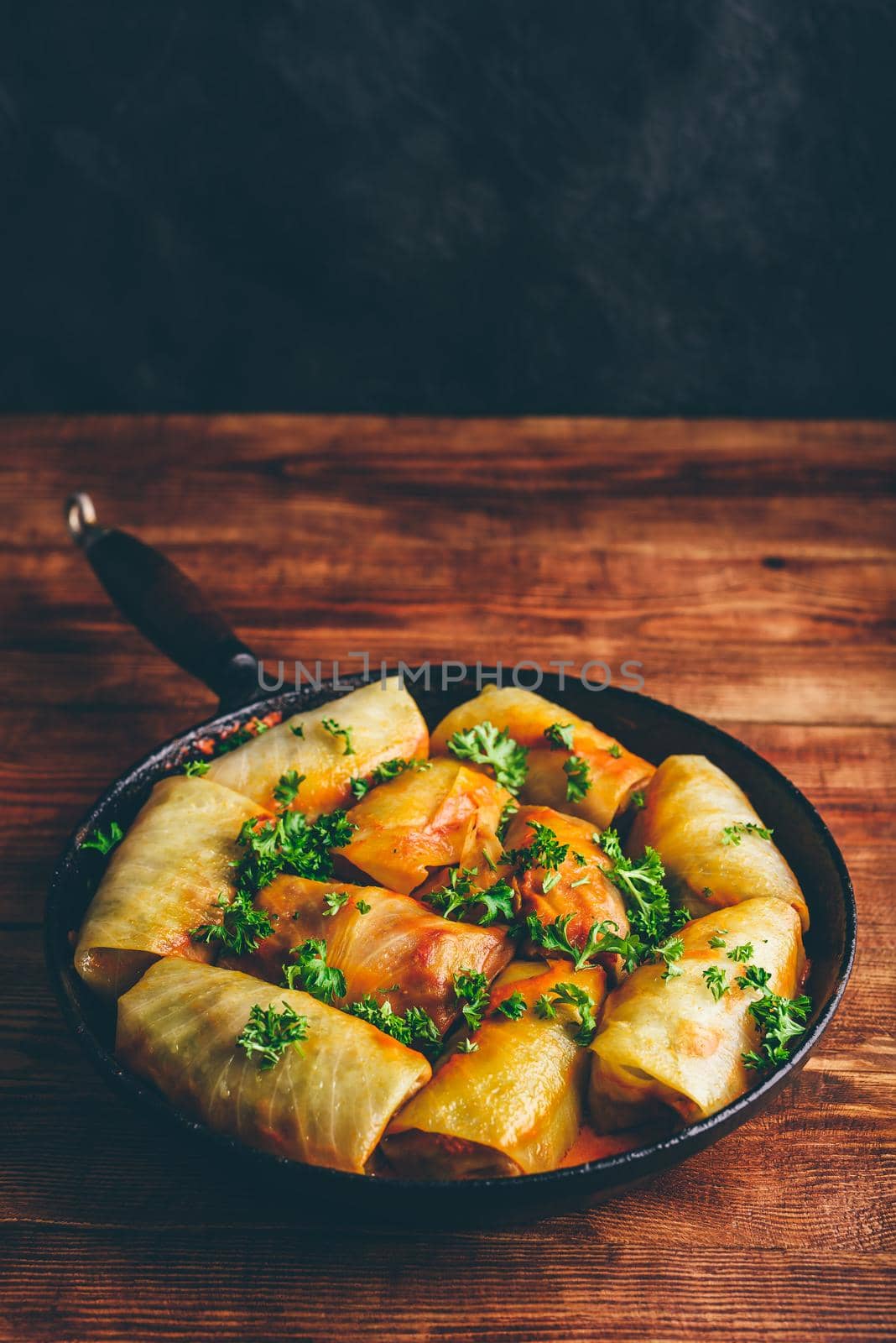 Cabbage Rolls Stuffed with Minced Pork in Frying Pan Served with Fresh Parsley
